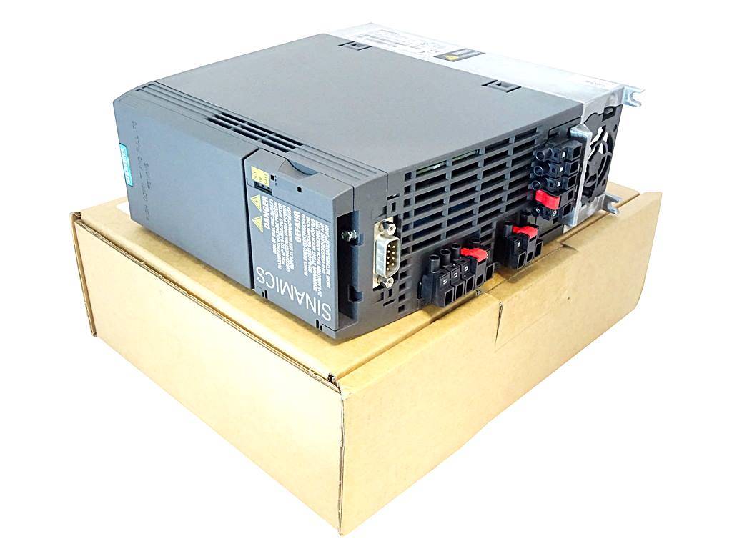 Ein industrielles Siemens-Elektronikmodul liegt auf einem Karton und zeigt seine Frontanschlüsse, Lüftungsschlitze und Warnhinweise.