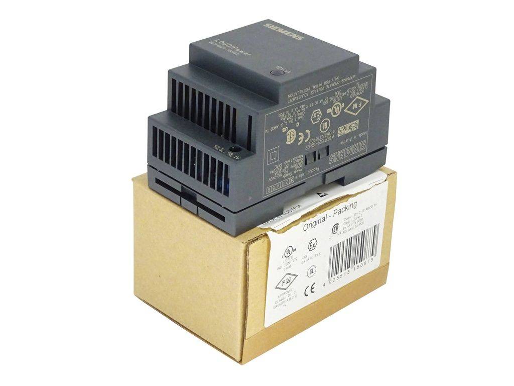 Ein schwarzes Siemens-Industrieelektronikmodul sitzt auf einem Karton mit Produktetikett und Barcode, vor weißem Hintergrund gezeigt.