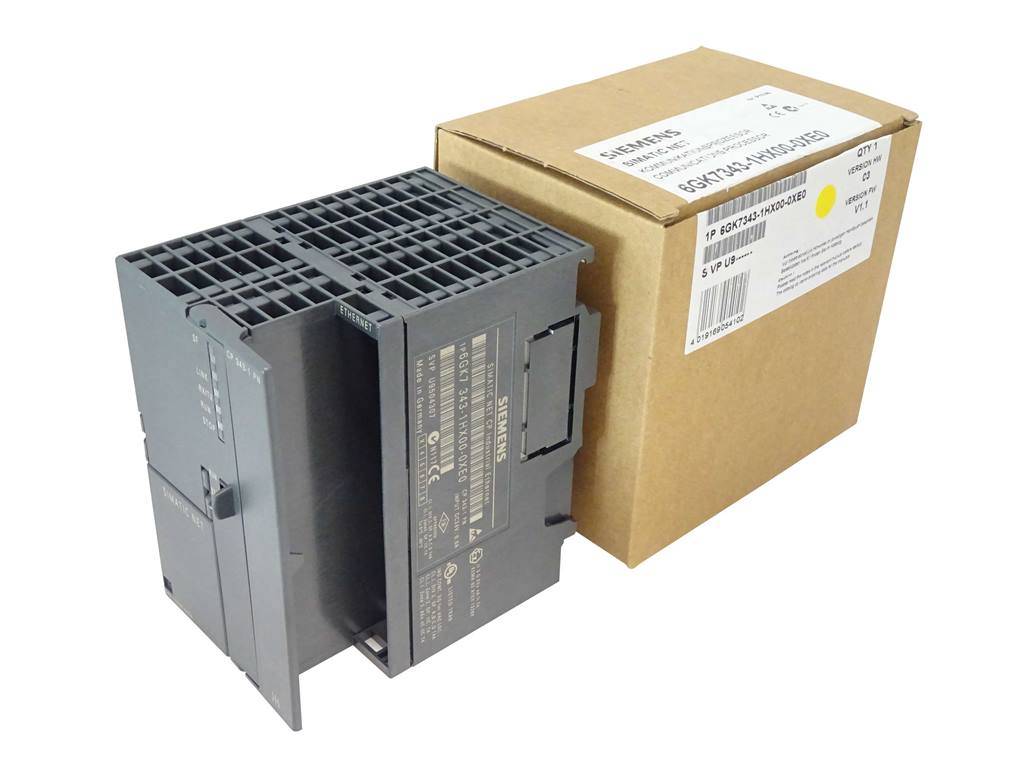 Ein schwarzes industrielles Elektronikmodul steht neben einem Versandkarton mit Produktetiketten auf weißem Hintergrund.