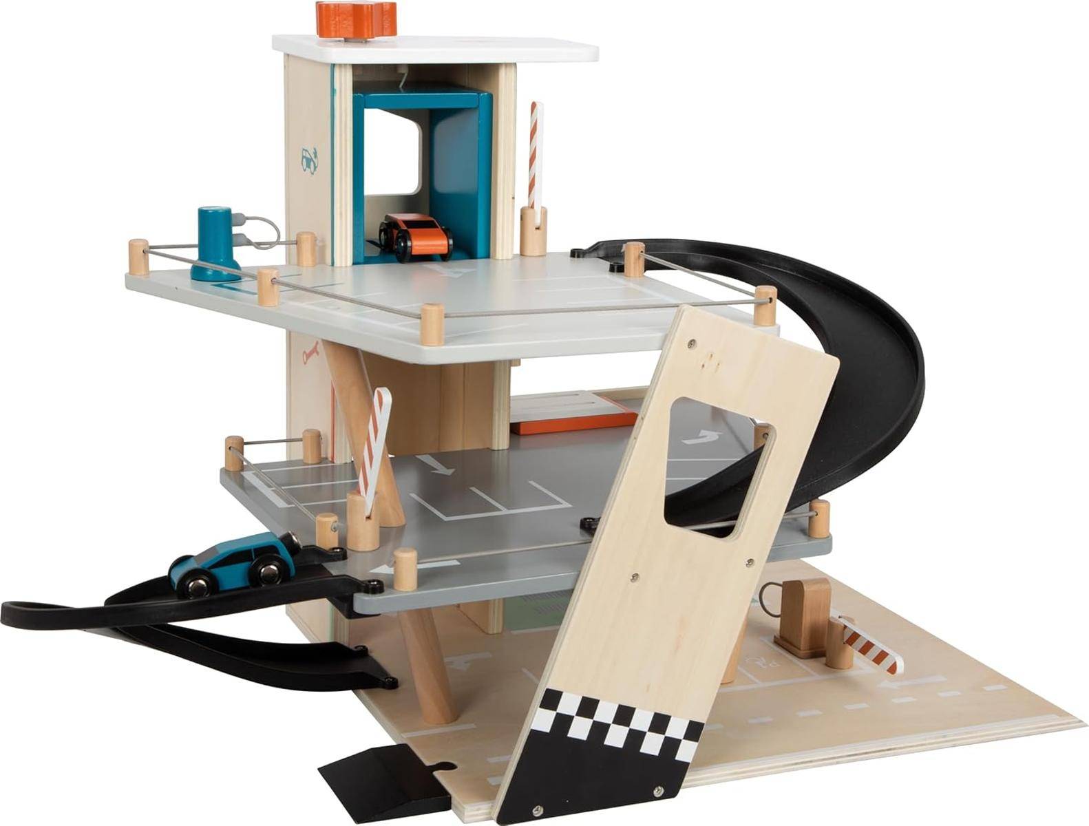 Eine hölzerne Spielzeugauto-Garage mit drei Ebenen, ausgestattet mit Rampen, einem kleinen Aufzug mit Hebel und Spielzeugautos, die auf verschiedenen Etagen geparkt sind.