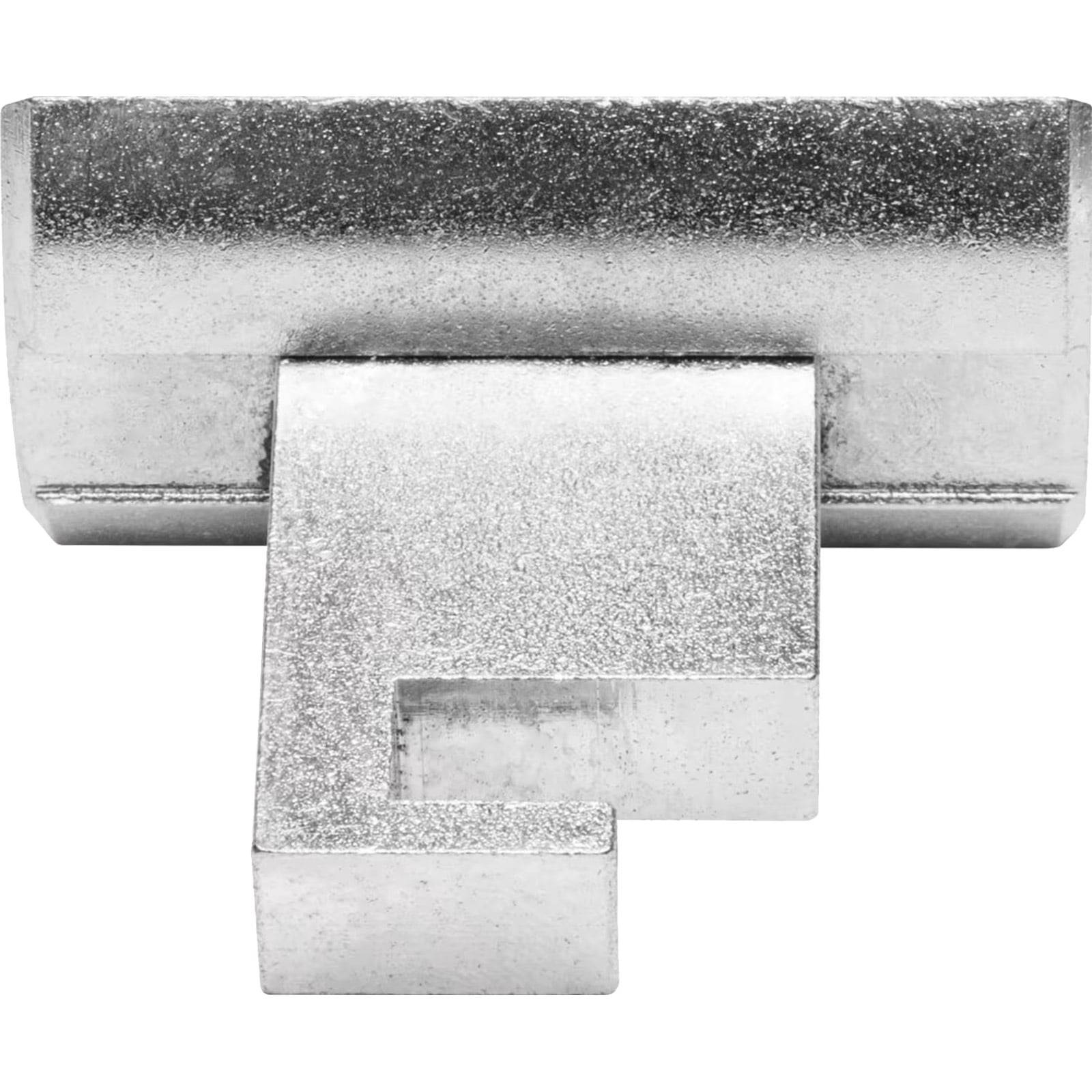 Ein silbernes Metallstück in Form des Buchstabens 'F', mit einer strukturierten Oberfläche und drei verbundenen Segmenten darunter, das einem kleinen architektonischen Gebilde ähnelt.