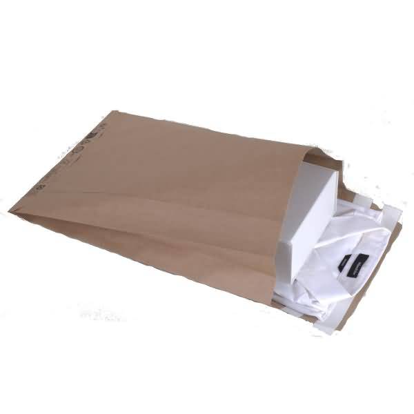 Braunes Versandumschlag aus Papier mit einem weißen Karton und gefalteter weißer Stoffverpackung, teilweise auf weißem Hintergrund geöffnet.