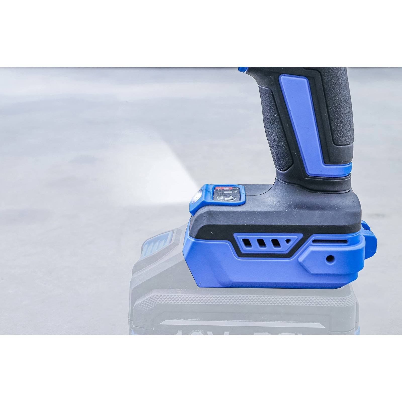 Eine Nahaufnahme eines blauen und schwarzen kabellosen Elektrowerkzeugs, die seinen Akku zeigt, vor einem unscharfen Hintergrund.