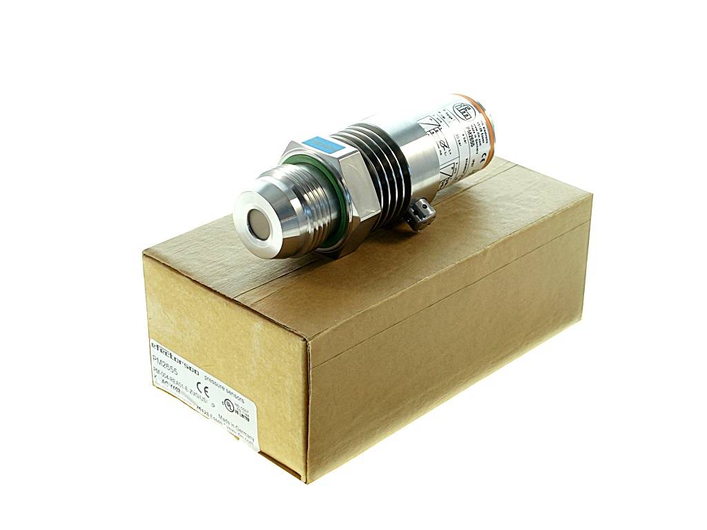 Metallischer Drucksensor/Steckverbinder, der auf einem schlichten Kartonkarton vor weißem Hintergrund liegt.