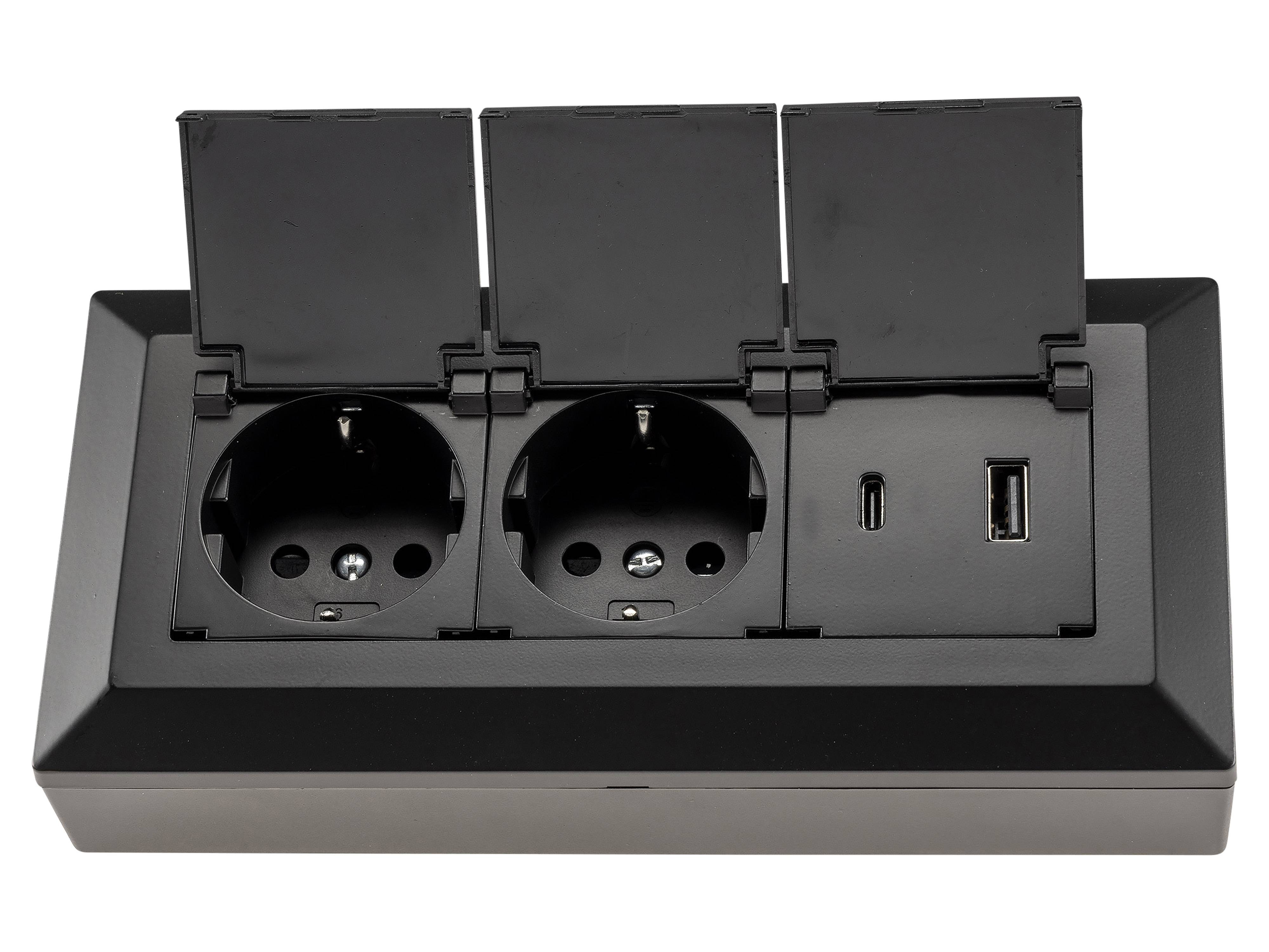 Ein schwarzer Stromverteiler verfügt über zwei europäische Steckdosen, einen USB-C-Anschluss und einen USB-A-Anschluss, alle mit Schutzdeckeln.
