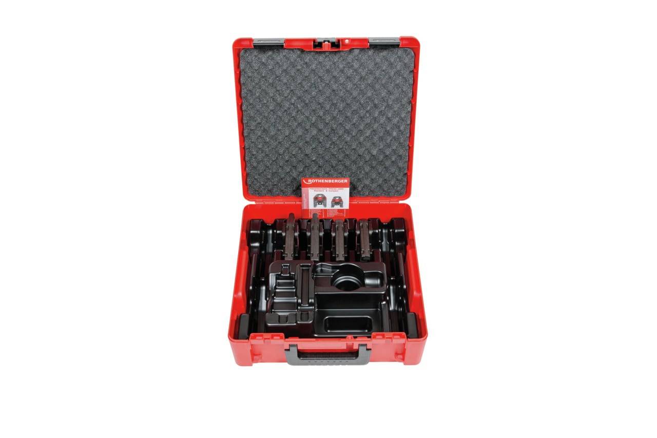 Rote Plastikbox mit verschiedenen schwarzen Werkzeugen ordentlich sortiert, mit geschlossenem Deckel, auf dem ein Logo und eine Namenskarte zu sehen sind.