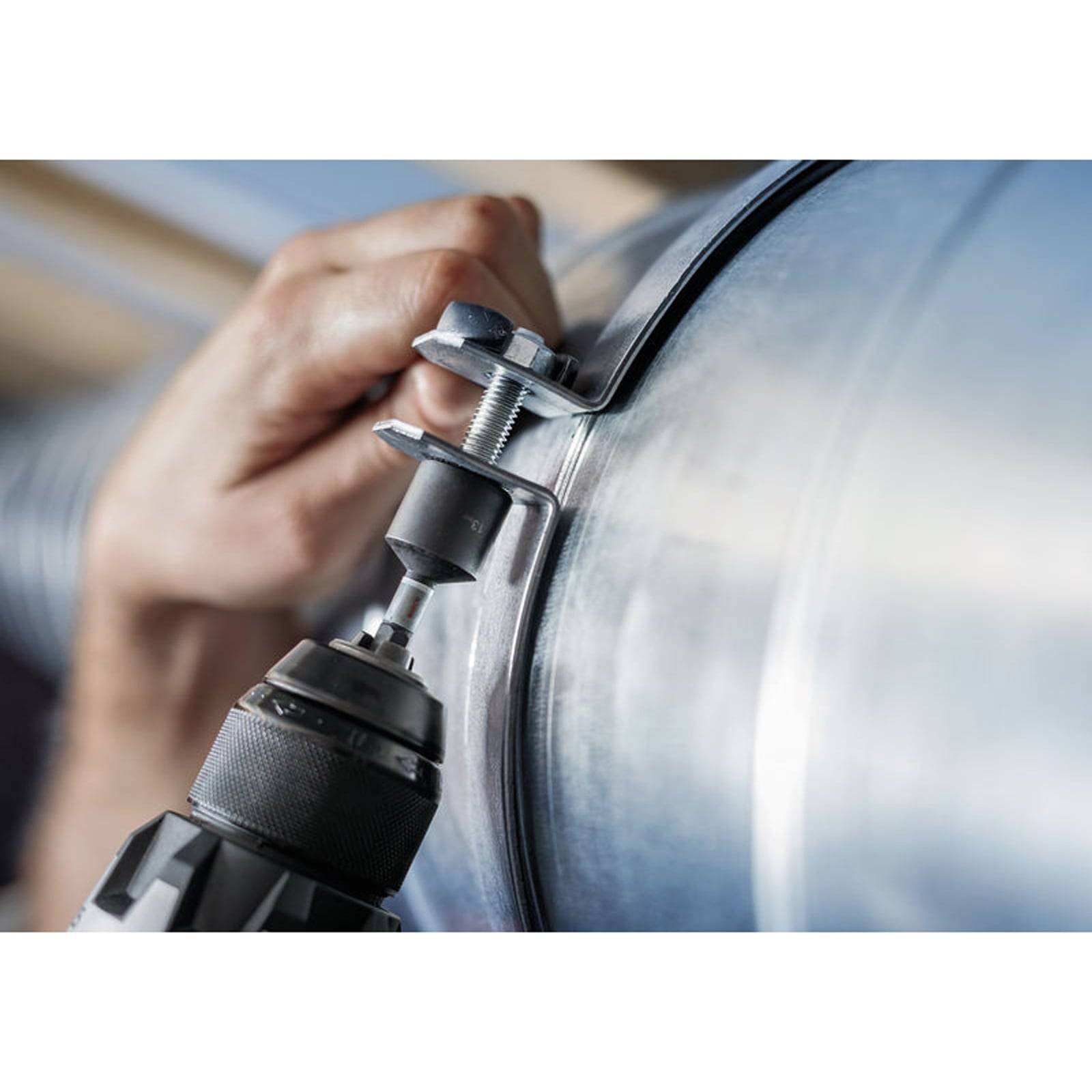 Eine Person verwendet ein Elektrowerkzeug, um eine Metallklemme um einen zylindrischen Gegenstand zu befestigen und damit Sicherungstechniken für Metallrohre zu demonstrieren.