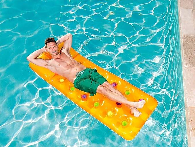 Ein Mann entspannt sich auf einem orangefarbenen aufblasbaren Poolfloss in einem Schwimmbecken.