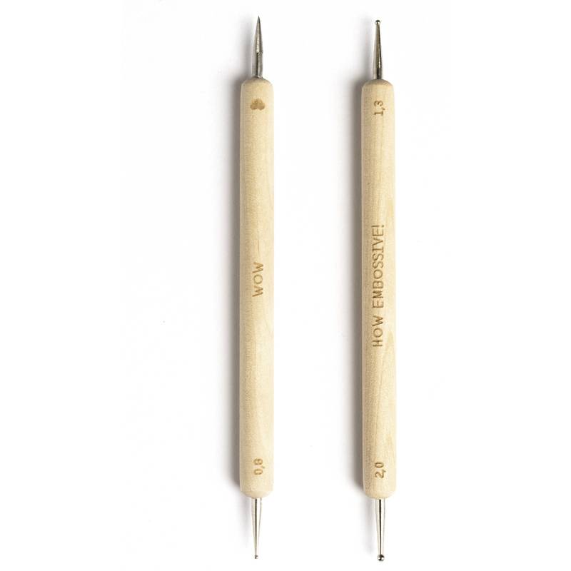 Zwei Holz-Prägewerkzeuge mit Metallspitzen. Das linke Werkzeug ist mit 'WOW' und '0,8' beschriftet, und das rechte Werkzeug ist mit 'HOW EMBOSSIVE!' und '1,3' beschriftet.