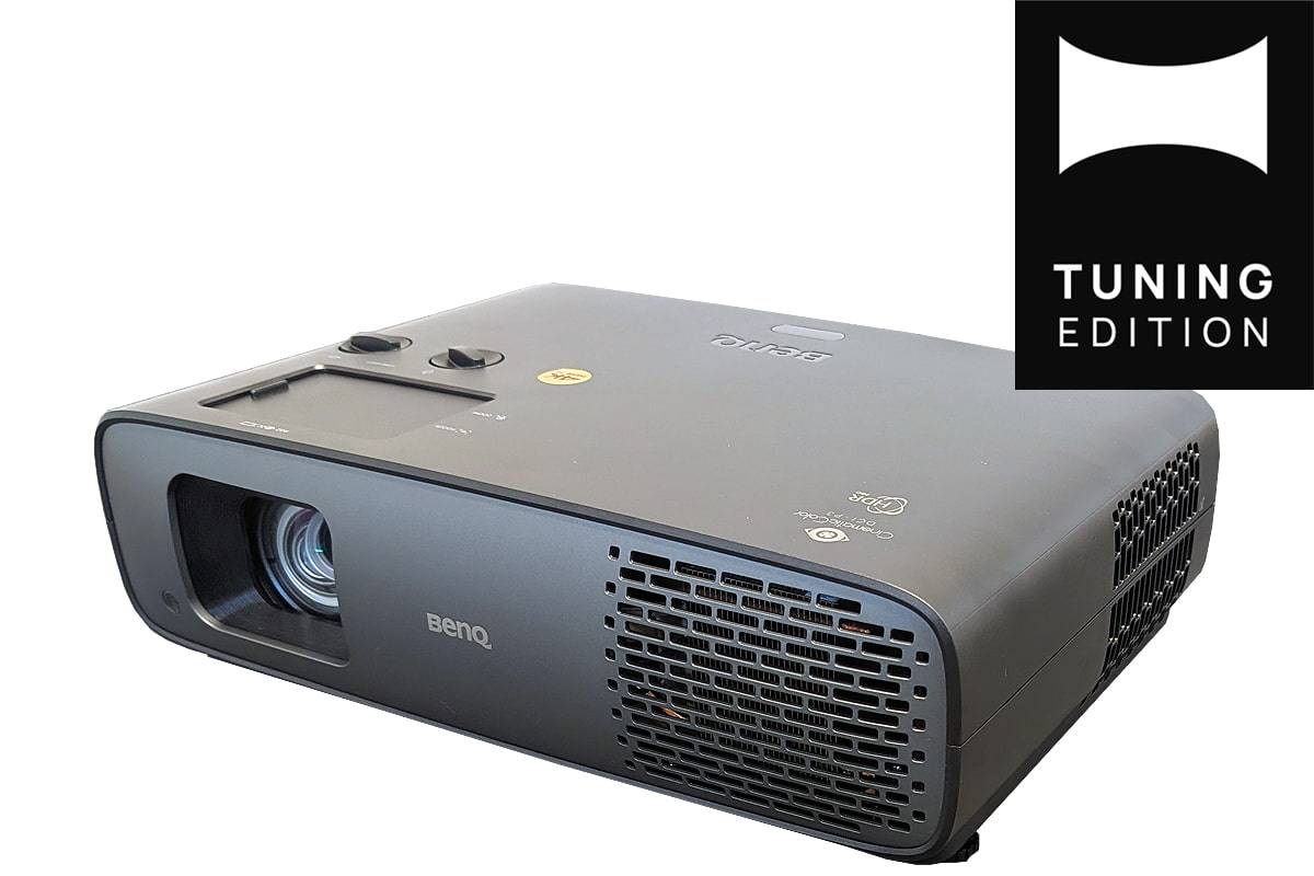 Schwarzer BenQ-Projektor in schräger Ansicht mit Objektiv, Steuerungstasten, Lüftungsöffnungen und einem 