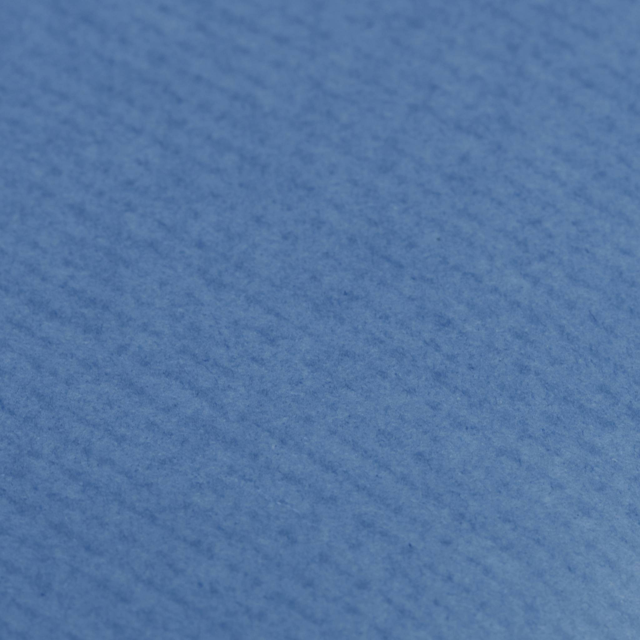 Nahaufnahme einer blauen strukturierten Stoff- oder Papierfläche ohne erkennbares Motiv.