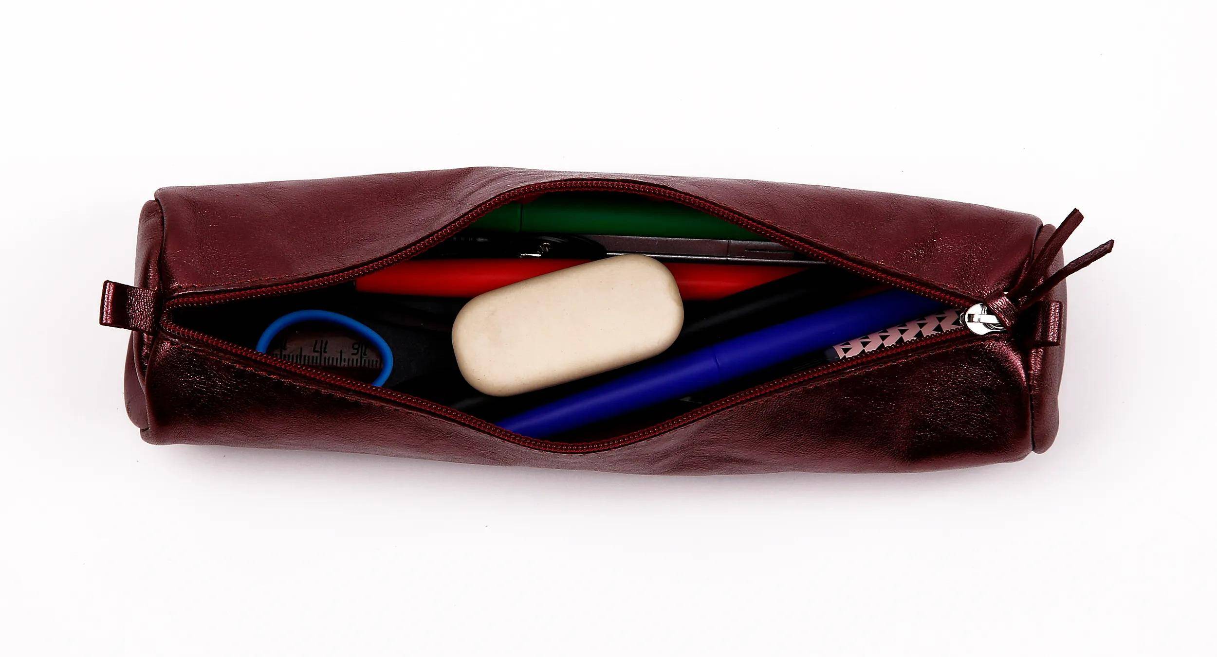 Offene kastanienbraune Federtasche mit Reißverschluss mit ein paar Schulmaterialien im Inneren, einschließlich eines blauen Stifts, eines Radiergummis und eines Bleistifts auf weißem Hintergrund