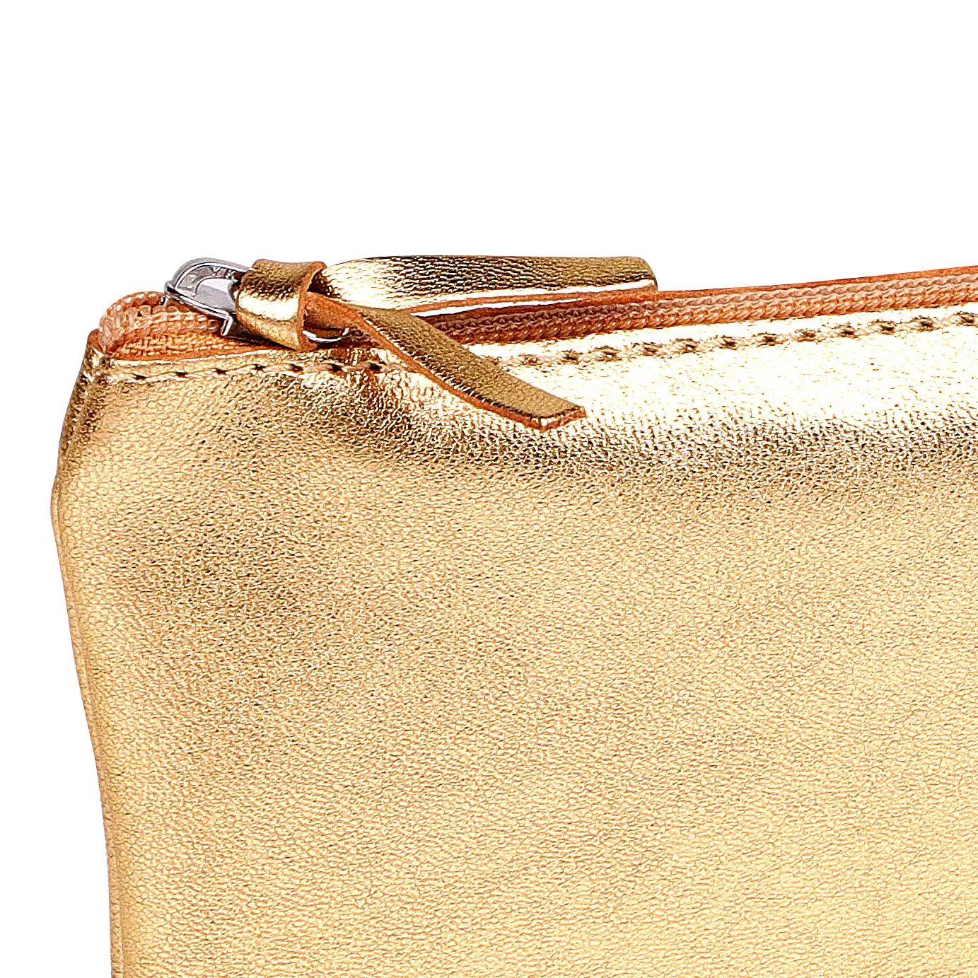 Goldmetallische Reißverschlusstasche mit Lederlasche auf einfachem weißem Hintergrund.