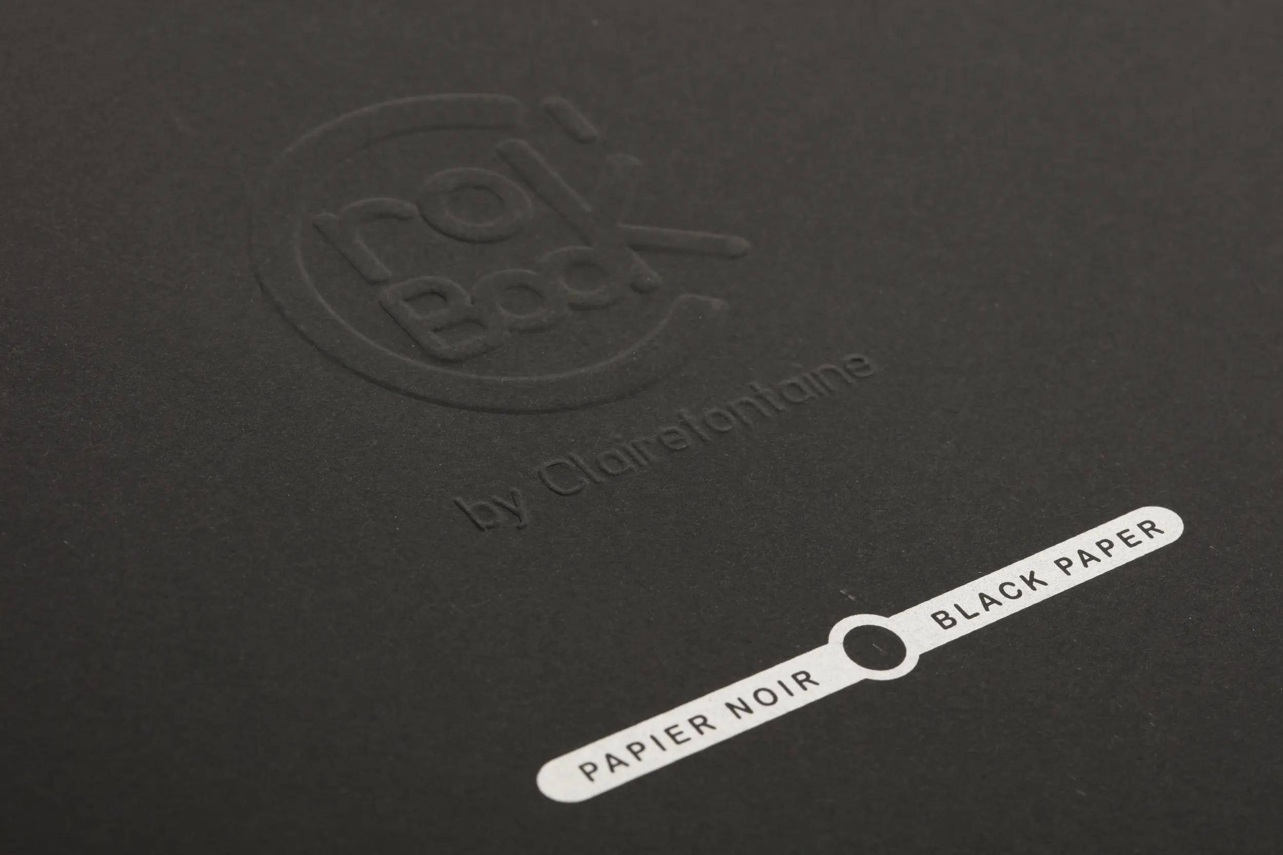 Schwarze Papierverpackung mit geprägtem Logo und einem Musteretikett mit der Aufschrift „PAPIER NOIR