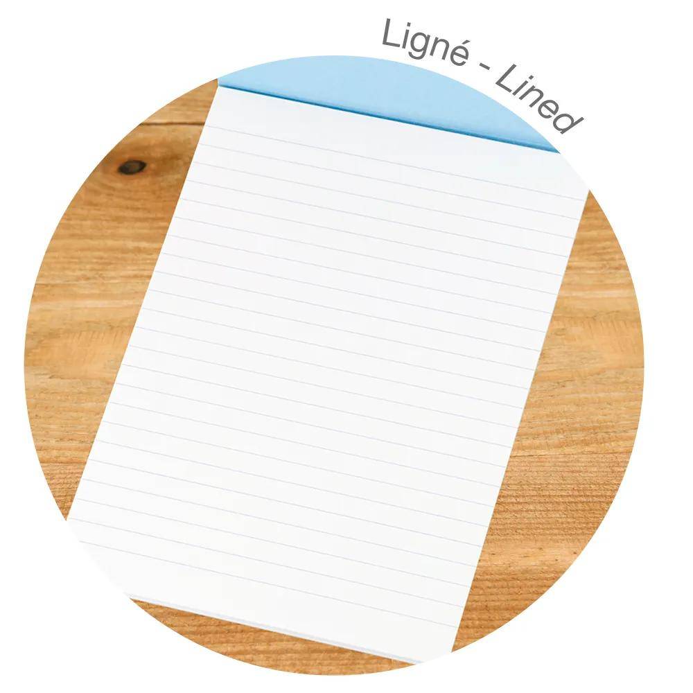 Leeres Notizbuchpapier mit Linien auf einer Holzoberfläche, dargestellt in einem kreisförmigen Produktbild mit der Bezeichnung „Ligné - Lined