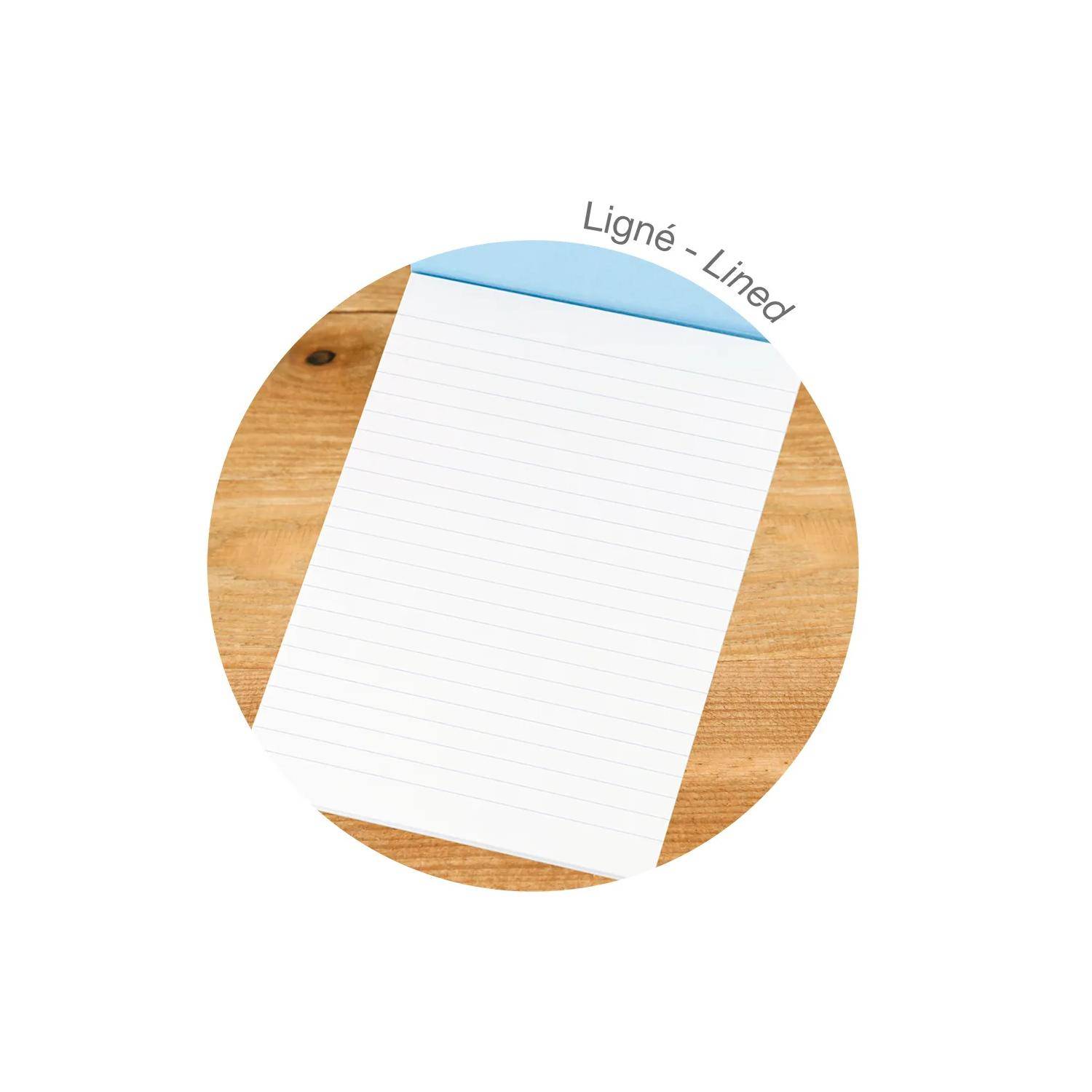 Ein leeres liniertes Notizblock auf einer Holzoberfläche, oben mit "Ligné - Lined"" beschriftet.