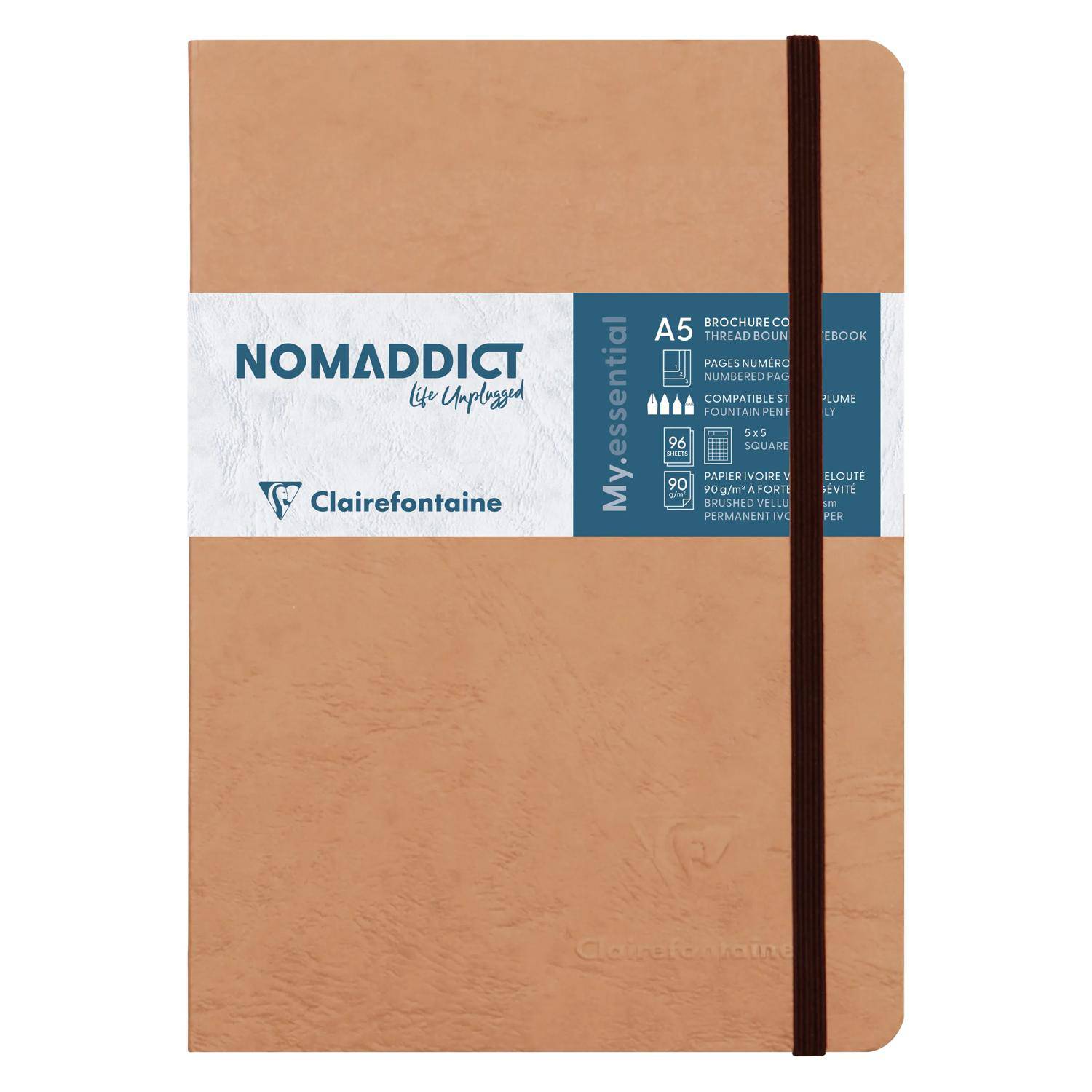 Notizbuch im A5-Format mit Lederoptik in Tan-Farbe, elastischem Band und "NOMADDICT"" Clairefontaine-Etikett auf dem Umschlag.