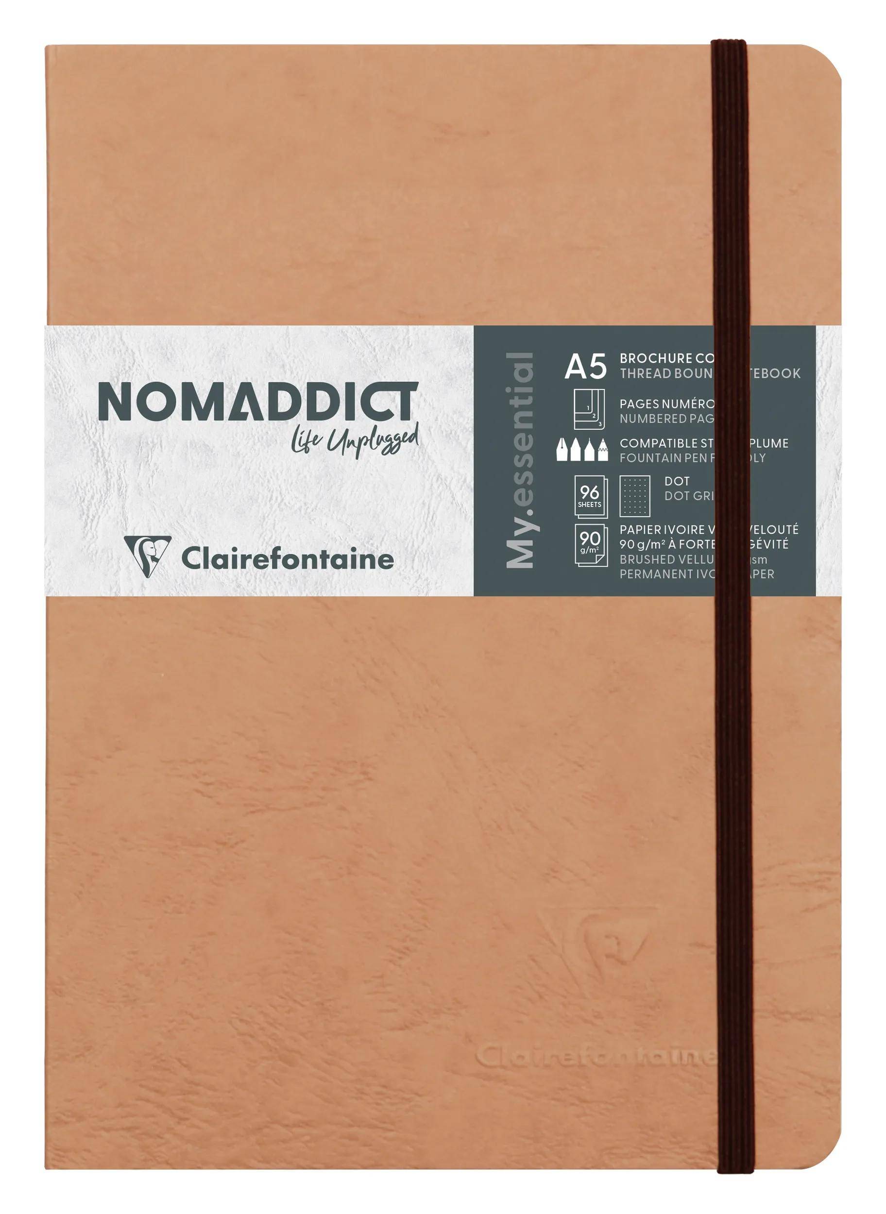 Notizbuch im Tan-Lederlook Clairefontaine 'NOMADDICT' A5 mit Gummiband zum Verschließen und weißem Produktband mit der Aufschrift 'My Essential'.