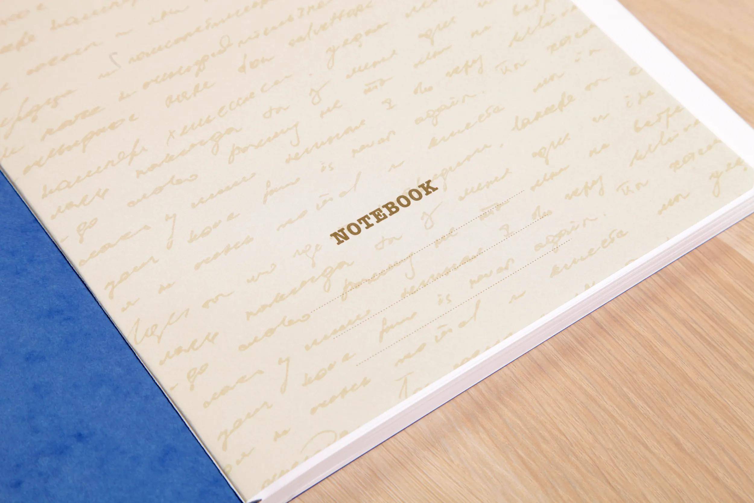 Ein geschlossenes cremefarbenes Notizbuch mit Kursivmuster und dem Wort „NOTEBOOK