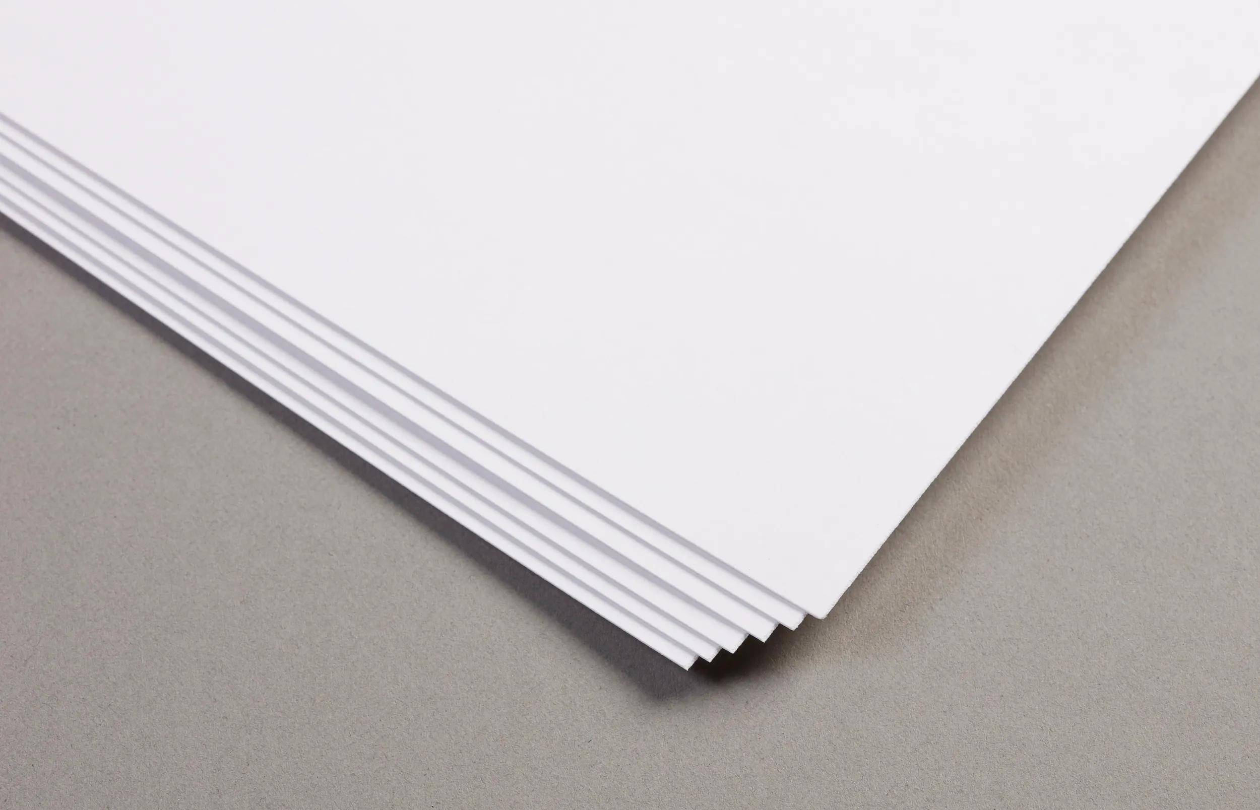 Stapel von weißen Papiertüchern, die auf einer grauen Oberfläche leicht fächerförmig ausgebreitet sind.