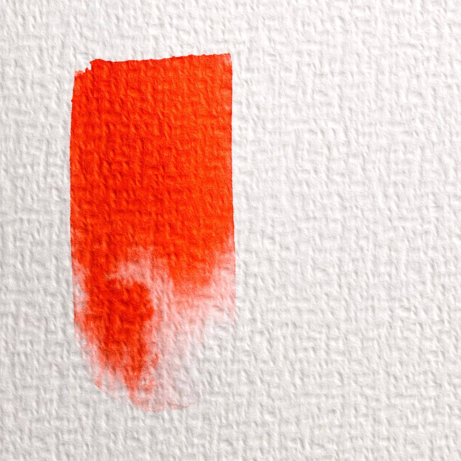 Ein einzelnes orange-rotes Farbmuster auf strukturiertem weißem Papier, das sich nach unten hin leicht abschwächt.