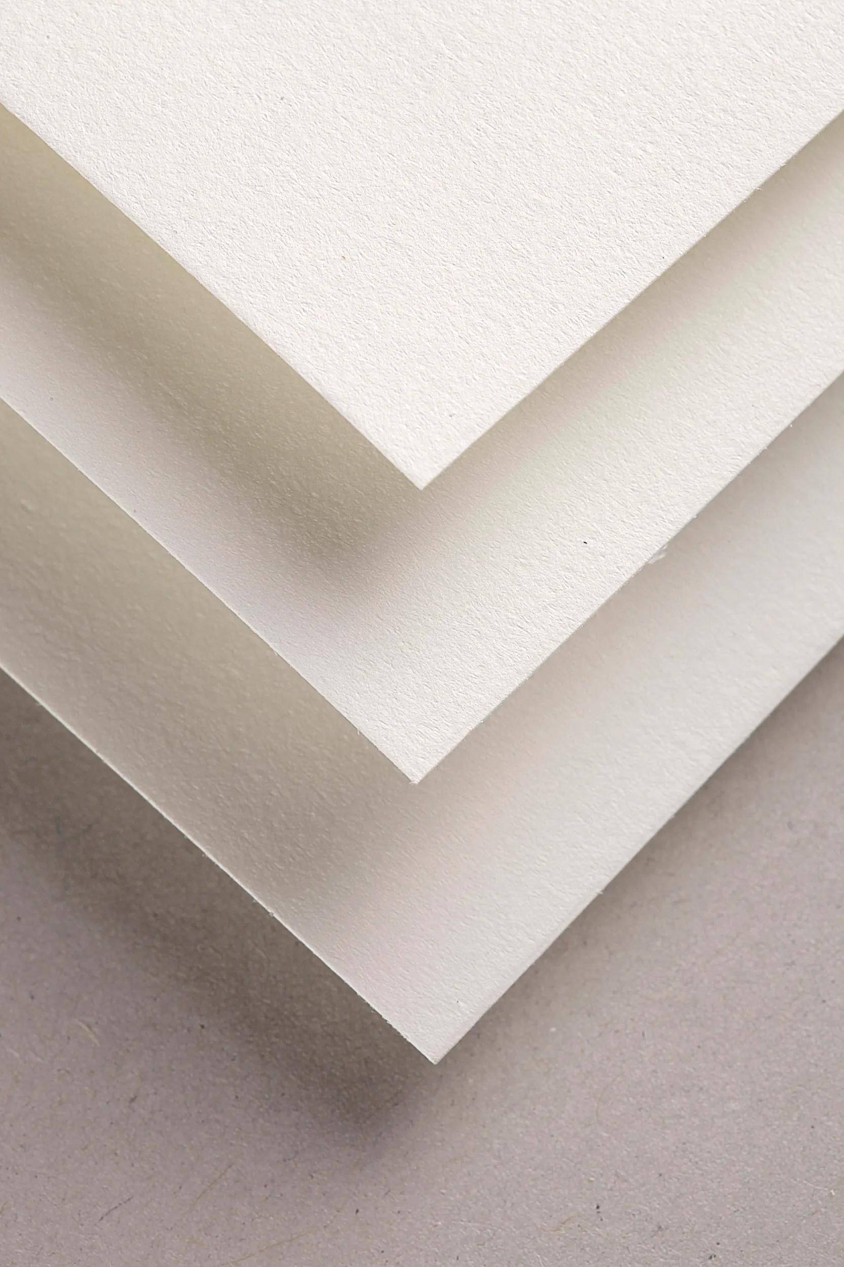 Nahaufnahme von gestapelten weißen Papierschichten, in versetzten V-Formen angeordnet mit strukturierten Oberflächen.
