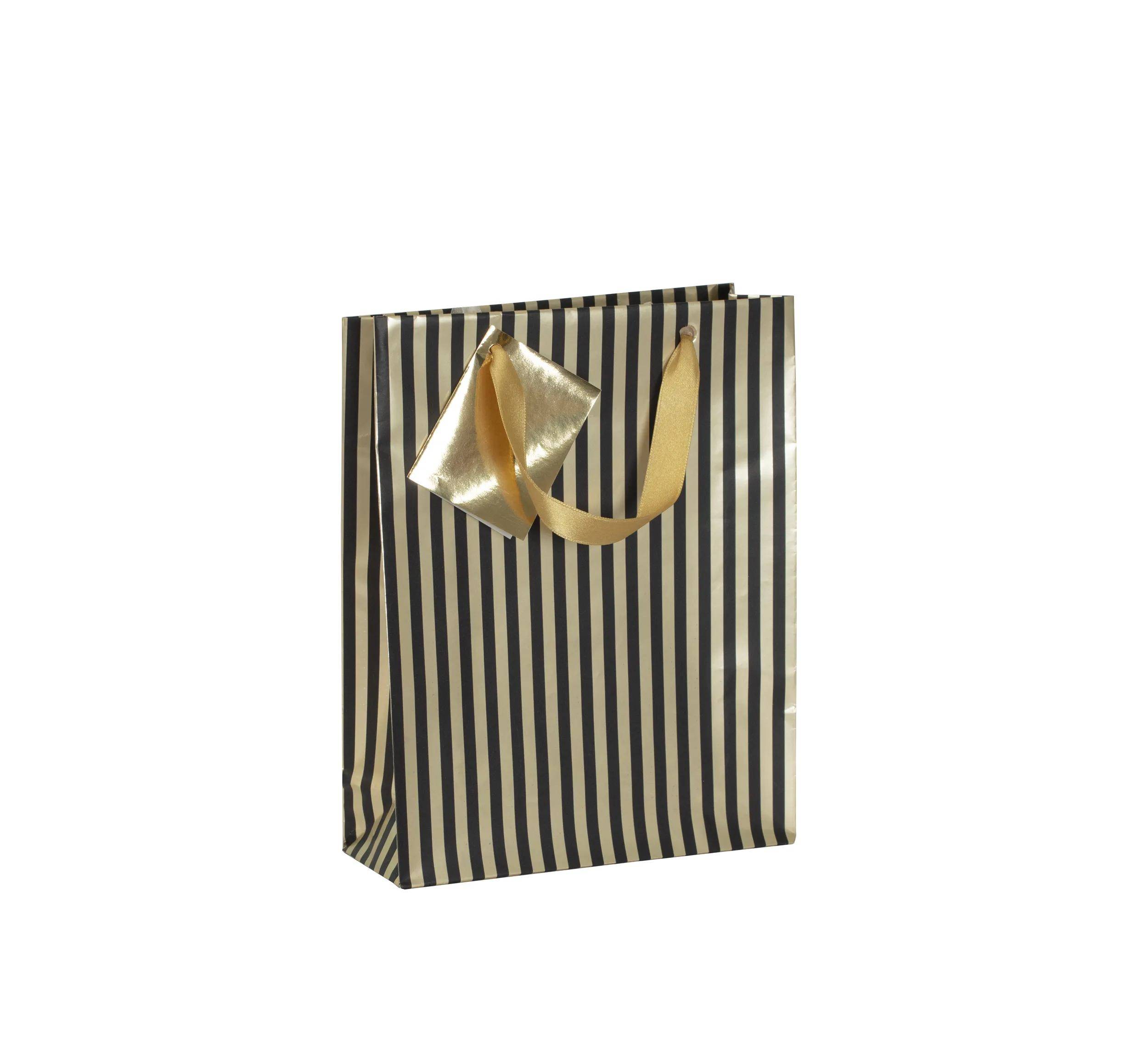 Eine gestreifte Geschenktasche mit vertikalen schwarzen und goldenen Linien, mit goldenen Bandgriffen, aufrecht gegen einen neutralen Hintergrund stehend.