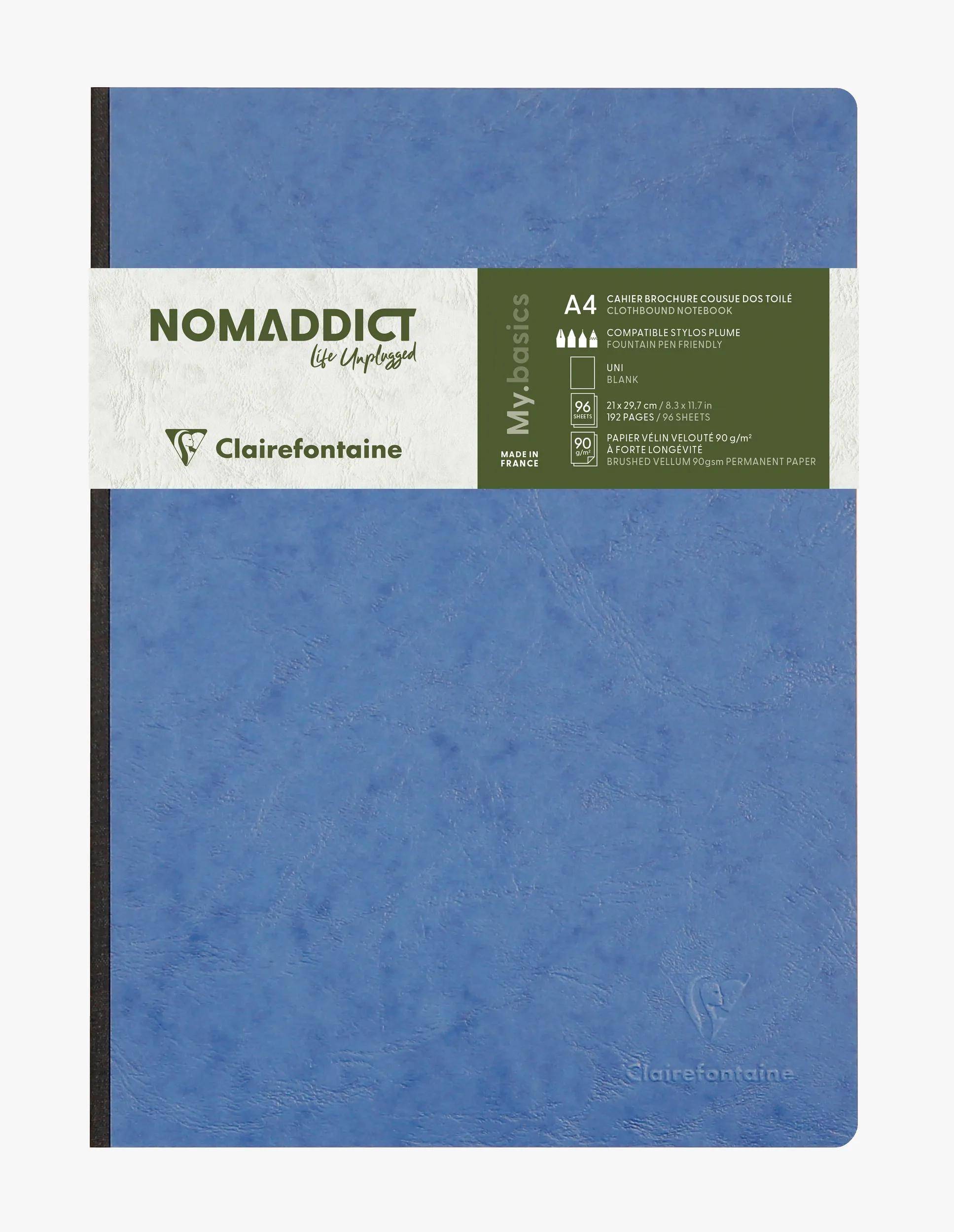 Blaues Clairefontaine 'NOMADDICT' Notizbuch mit weiß-grünem Bauchbinde, zeigt 'My Basics' Branding.
