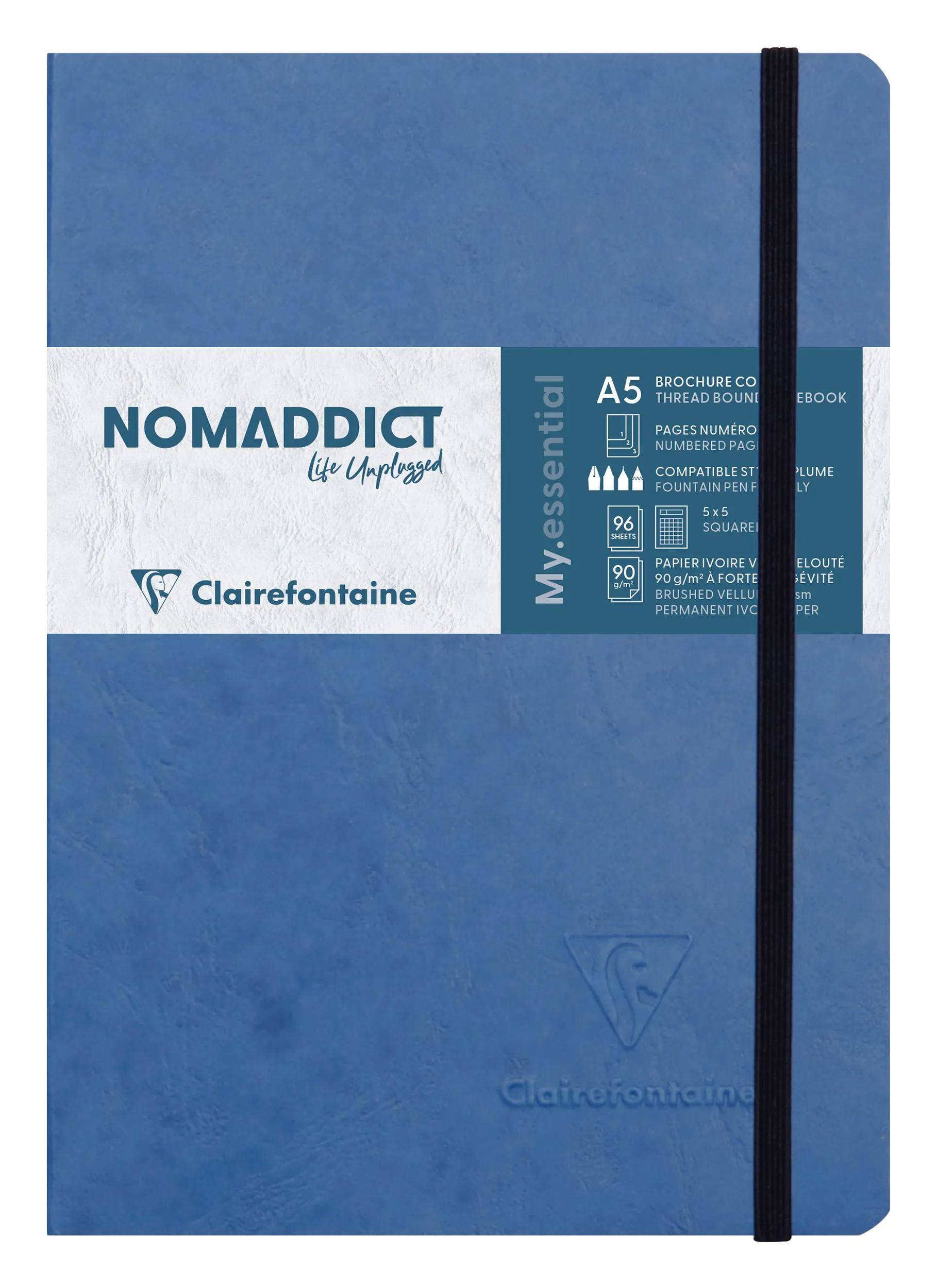 Blaues Clairefontaine Nomadict A5 Notizbuch mit Gummiband und weißem Etikett auf dem Umschlag.