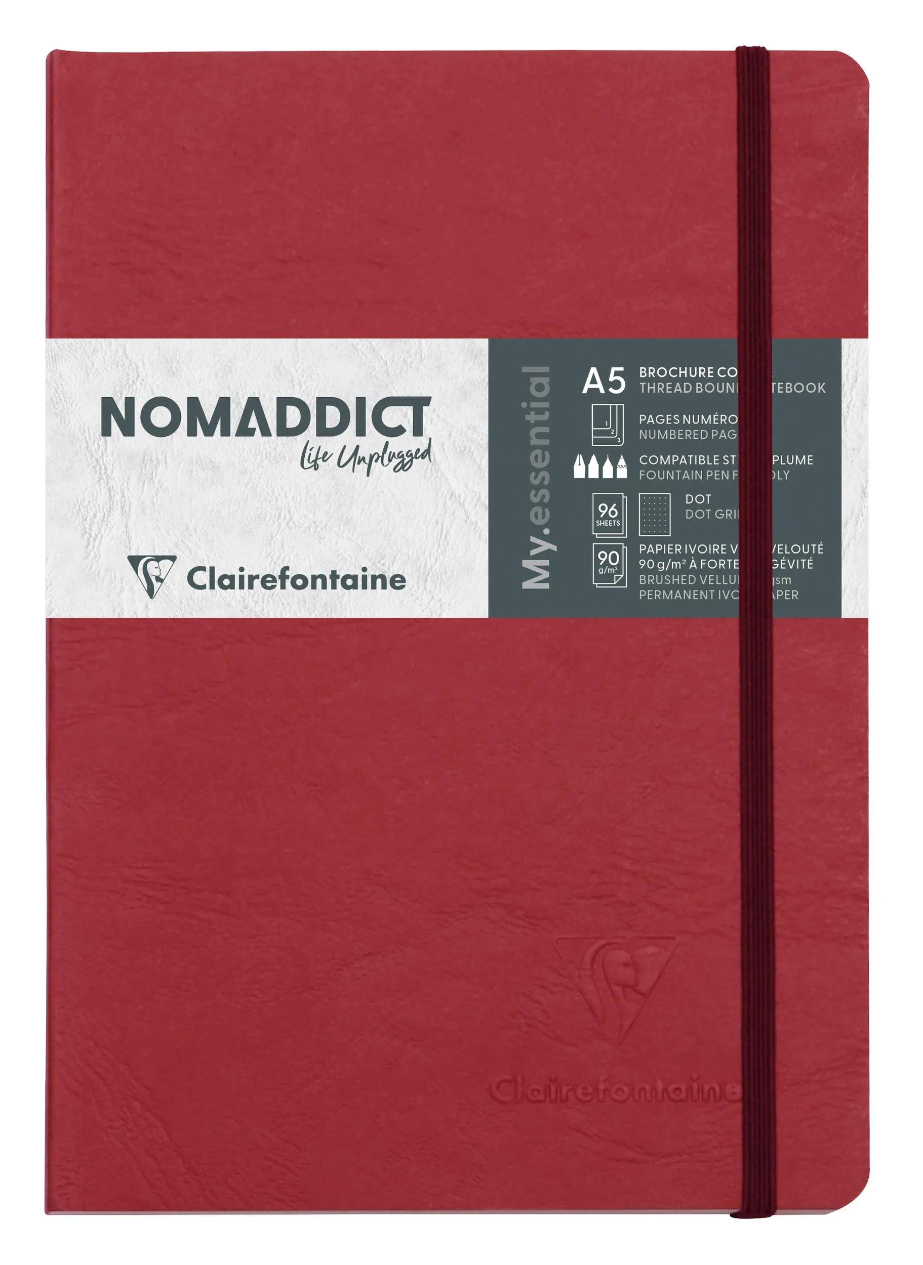 Rotes Clairefontaine NOMADDICT A5 Notizbuch mit Gummibandverschluss und weißem Etikettenband auf dem Umschlag.