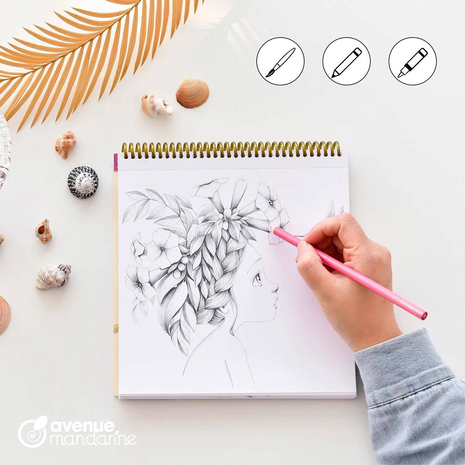 Eine Frau im Profil mit Bleistift zeichnen, mit Blumen und geflochtenen Haaren in einem Spiralblock, mit einem rosa Stift auf einem weißen Schreibtisch.