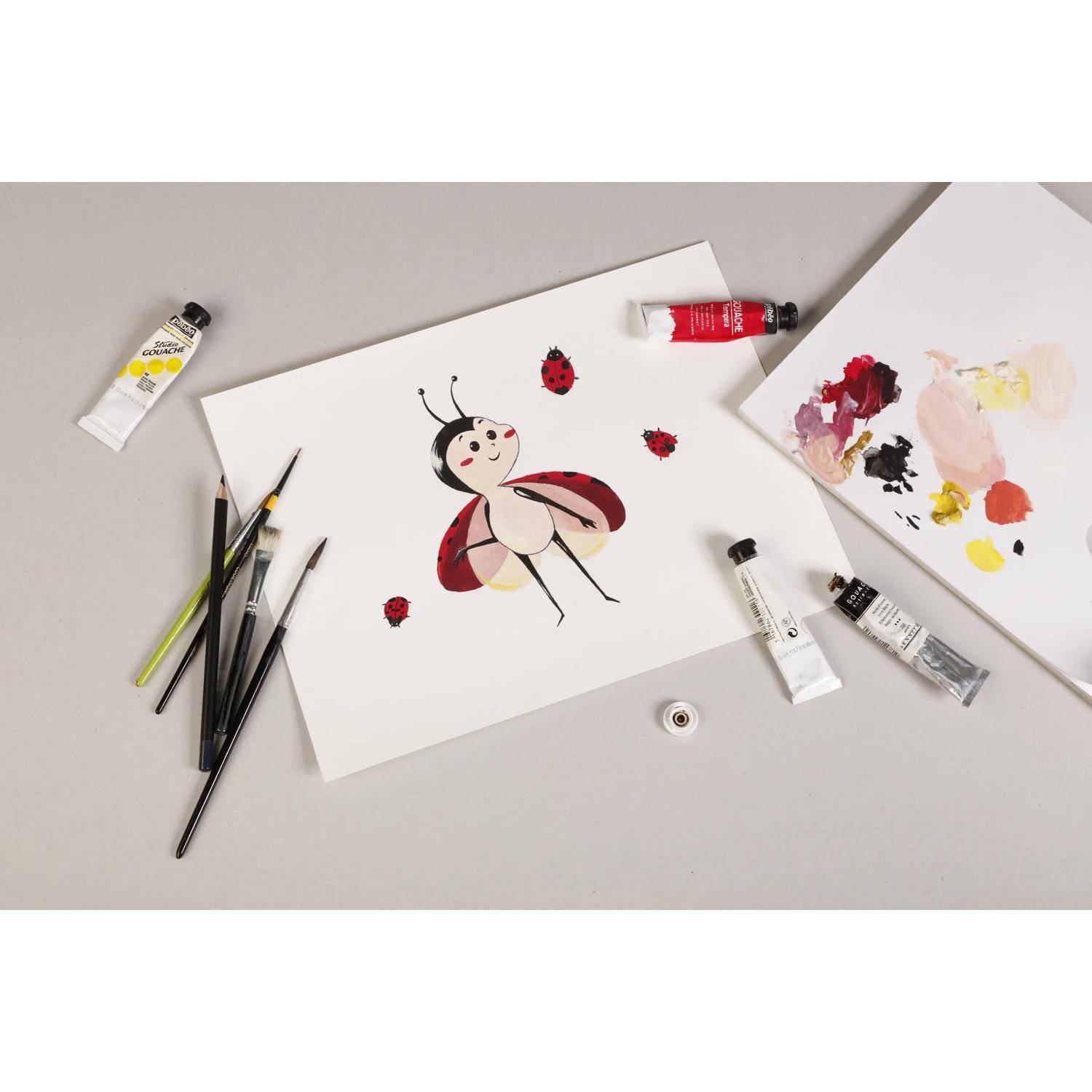 Draufsicht auf eine Malausstattung mit einer Marienkäfer-Illustration auf Papier, umgeben von Pinseln, Farbtuben und einer Palette mit gemischten Farben.