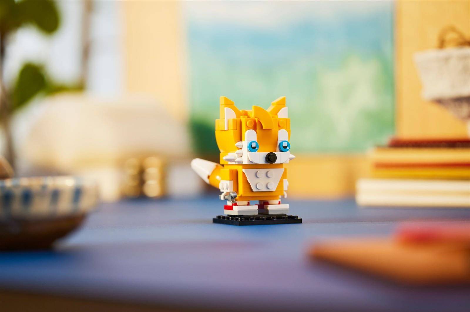 Kleine LEGO-ähnliche Fuchsfigur, die auf einem Tisch steht, mit unscharfem Zimmer im Hintergrund.