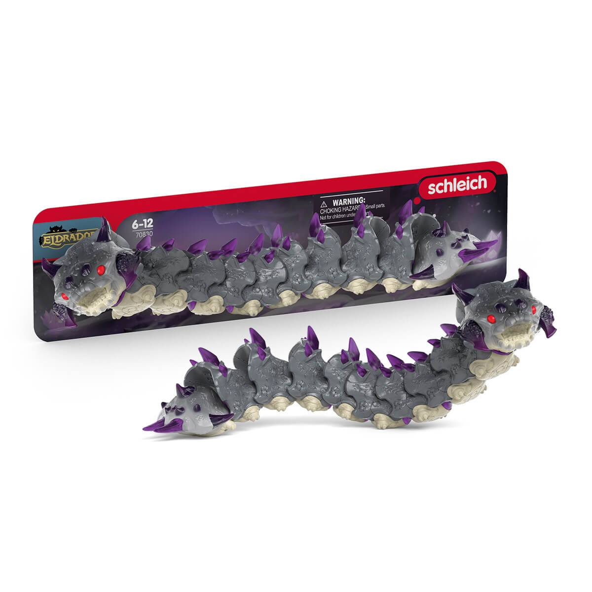 Eine Spielzeugdrachenfigur mit violetten Stacheln und roten Augen, präsentiert in einer Verpackung mit der Bezeichnung 