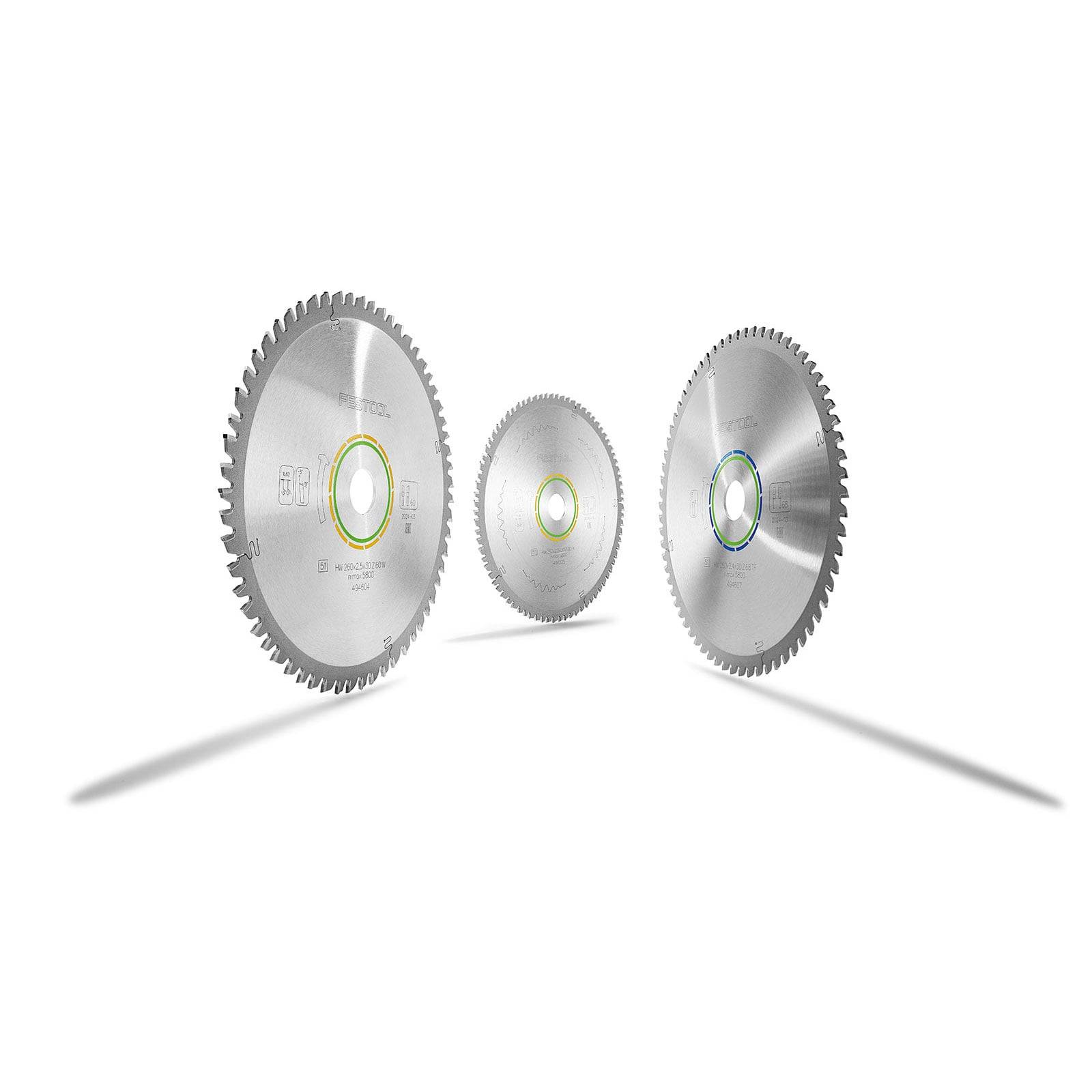 Drei Kreissägeblätter mit Metallzähnen stehen aufrecht und werfen Schatten auf einem schlichten weißen Hintergrund.