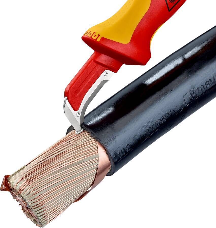 Nahaufnahme eines rot-gelben Abisolierzeugs, das die schwarze Isolierung von einem mehradrigen elektrischen Draht entfernt und die Kupferstränge freilegt.