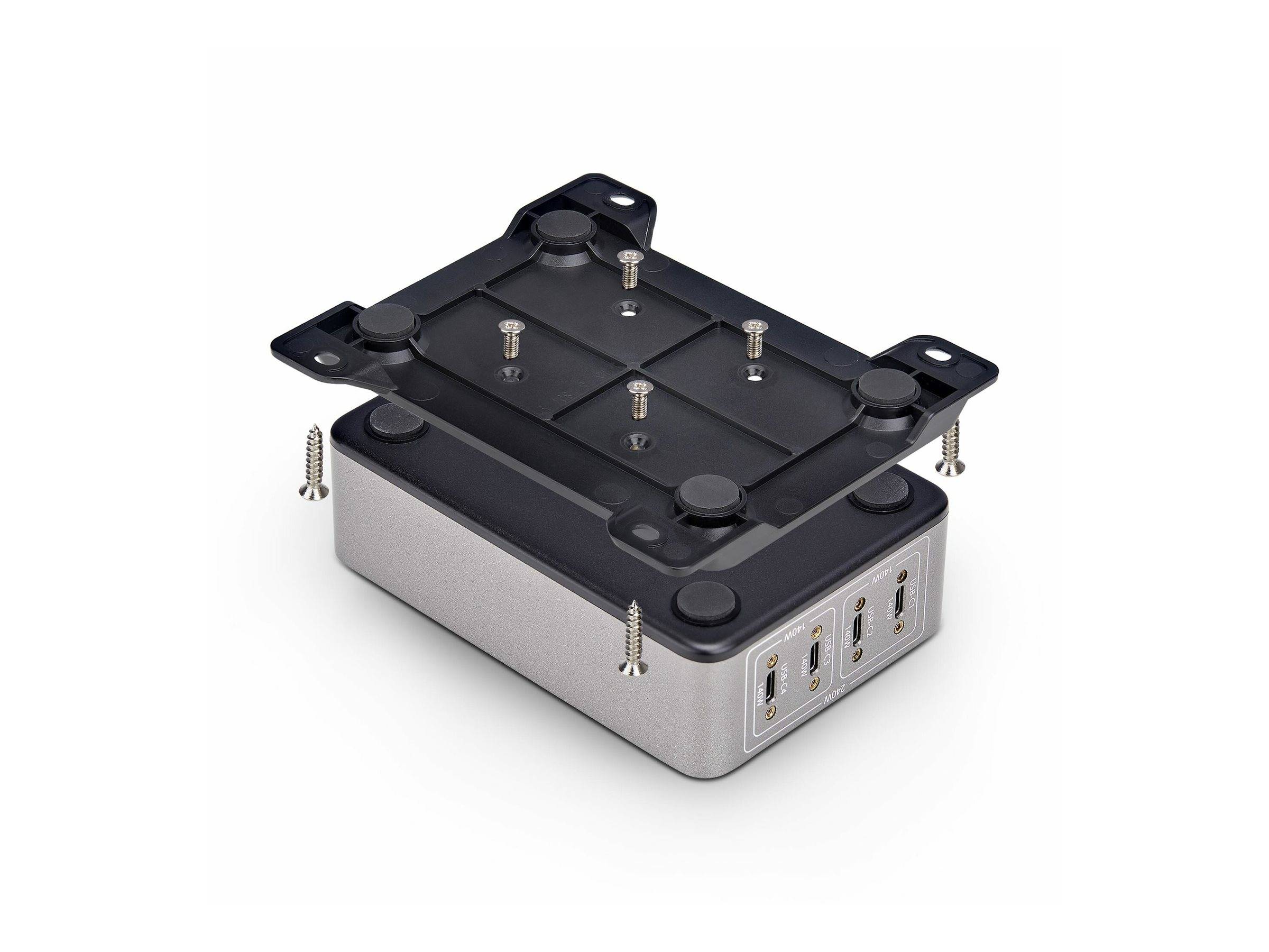 Eine Metallbefestigungshalterung mit Schrauben ist über einem silbernen Gerät mit drei USB-Anschlüssen an seiner Seite positioniert.