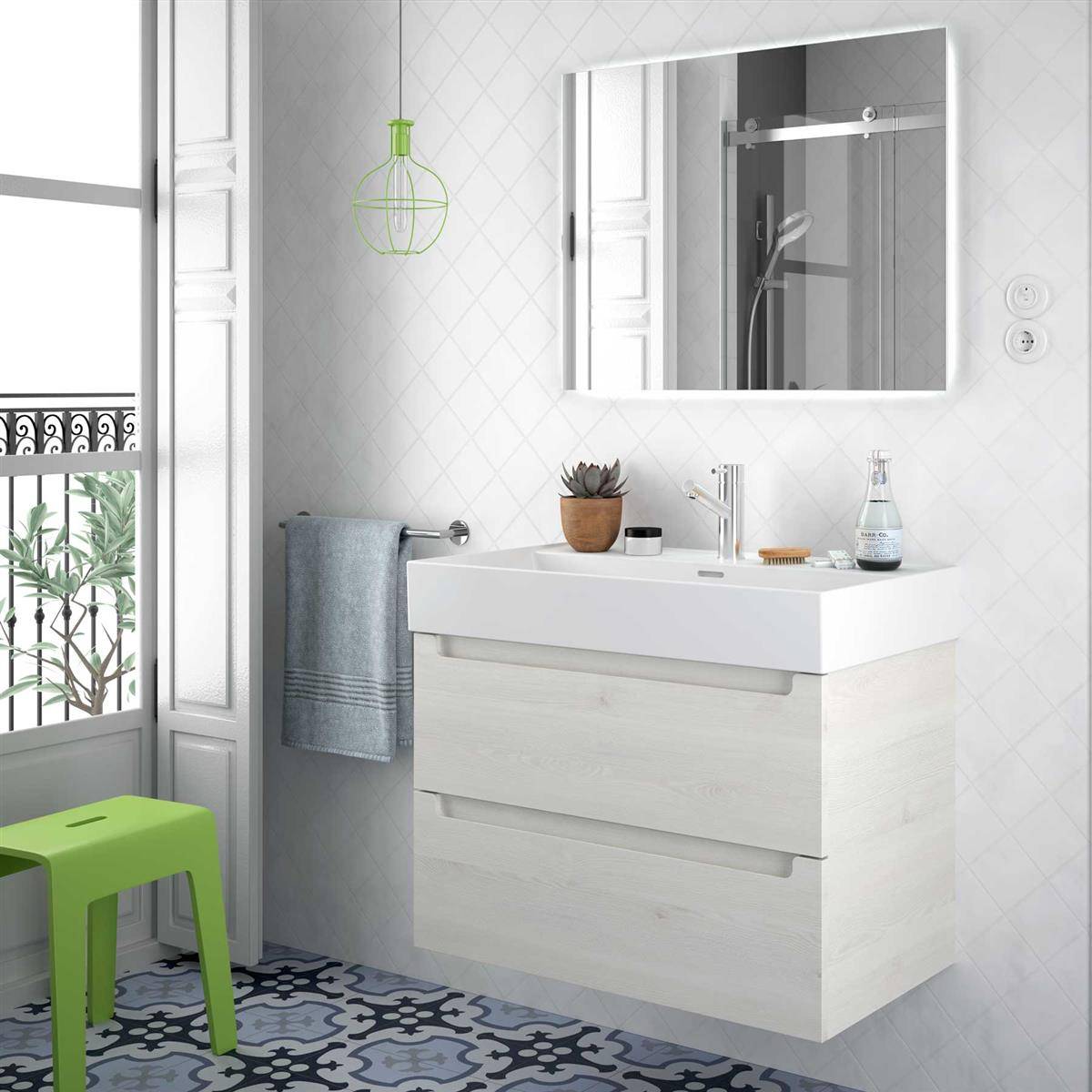 Modernes Badezimmer mit schwebendem weißem Waschtisch, Spiegel, Waschbecken, Handtuch und kleinem grünem Hocker neben einem hellen Fenster.