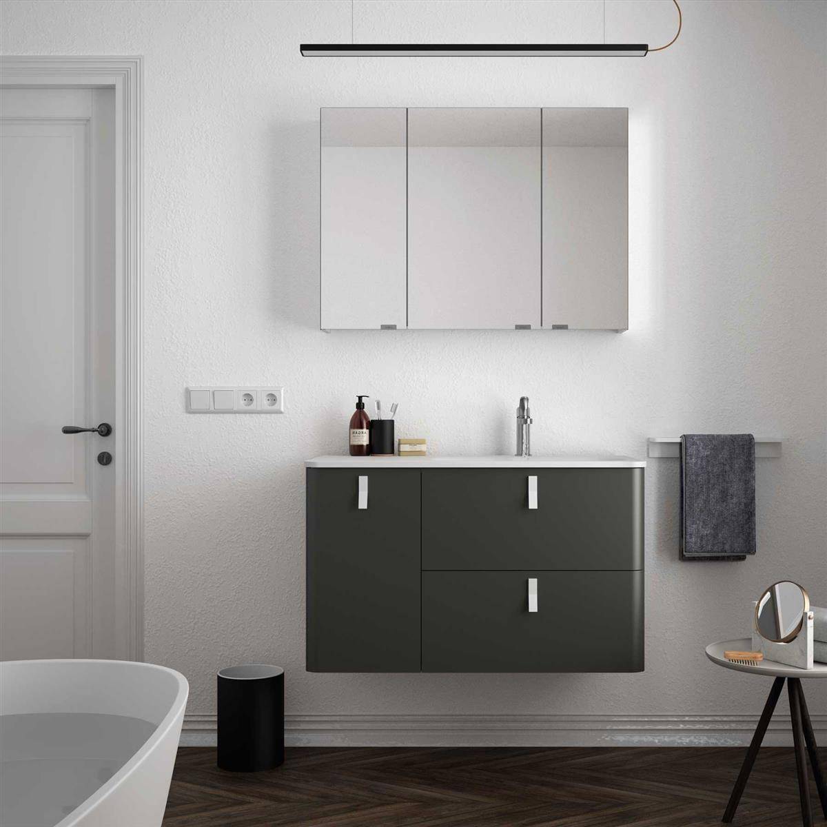 Modernes Badezimmer mit Badewanne, an der Wand montiertem Waschtisch und Spiegelschrank, Handtuchhalter, Waschbecken und minimalistischen Schwarz-Weiß-Armaturen.
