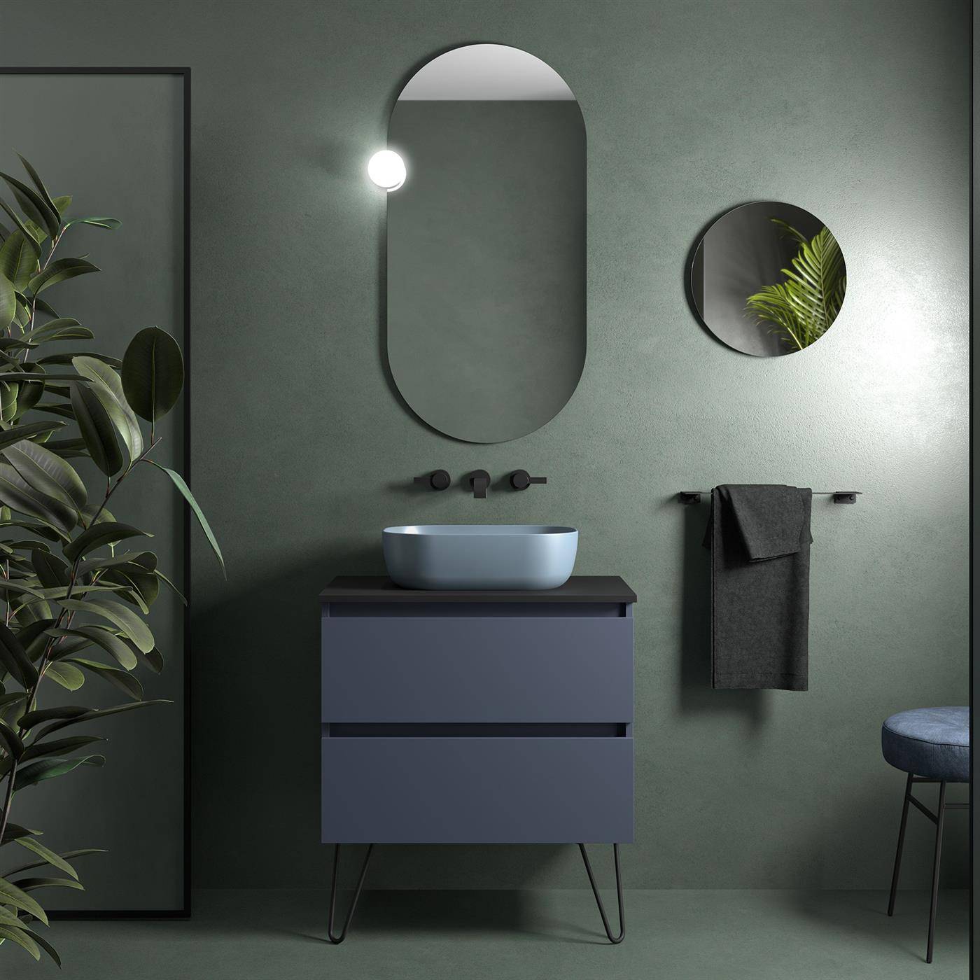 Modernes Badezimmer-Waschtisch mit blauem Becken-Waschbecken, ovalem Spiegel, rundem Wandspiegel, Handtuchhalter und Pflanzen-Akzent vor grünen Wänden.