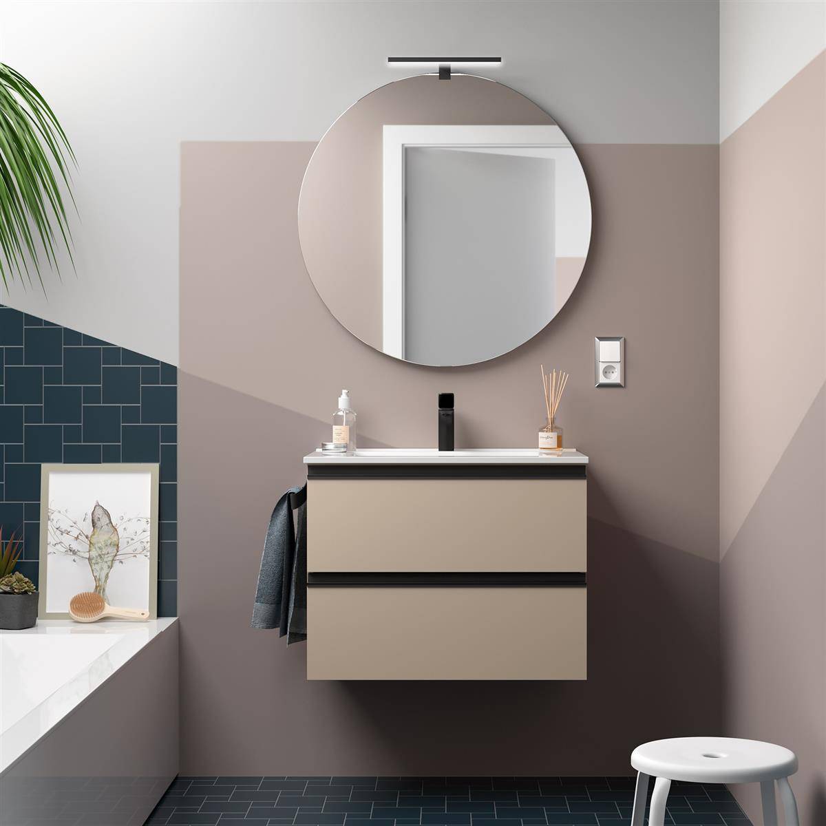 Modernes Badezimmer mit schwebendem beigefarbenem Waschtisch, rundem Spiegel, Wandleuchte, dunkelblauem Fliesenakzenten und weißem Hocker neben einem Badewannenbereich.