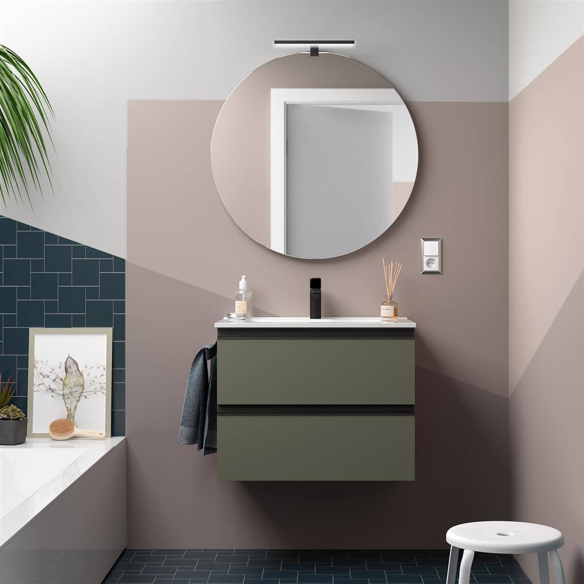 Modernes Badezimmerinterieur mit rundem Spiegel über einem wandmontierten olivefarbenen Waschtisch, weißem Hocker und Badewannenbord mit Rahmenbildern und Pflanzen.