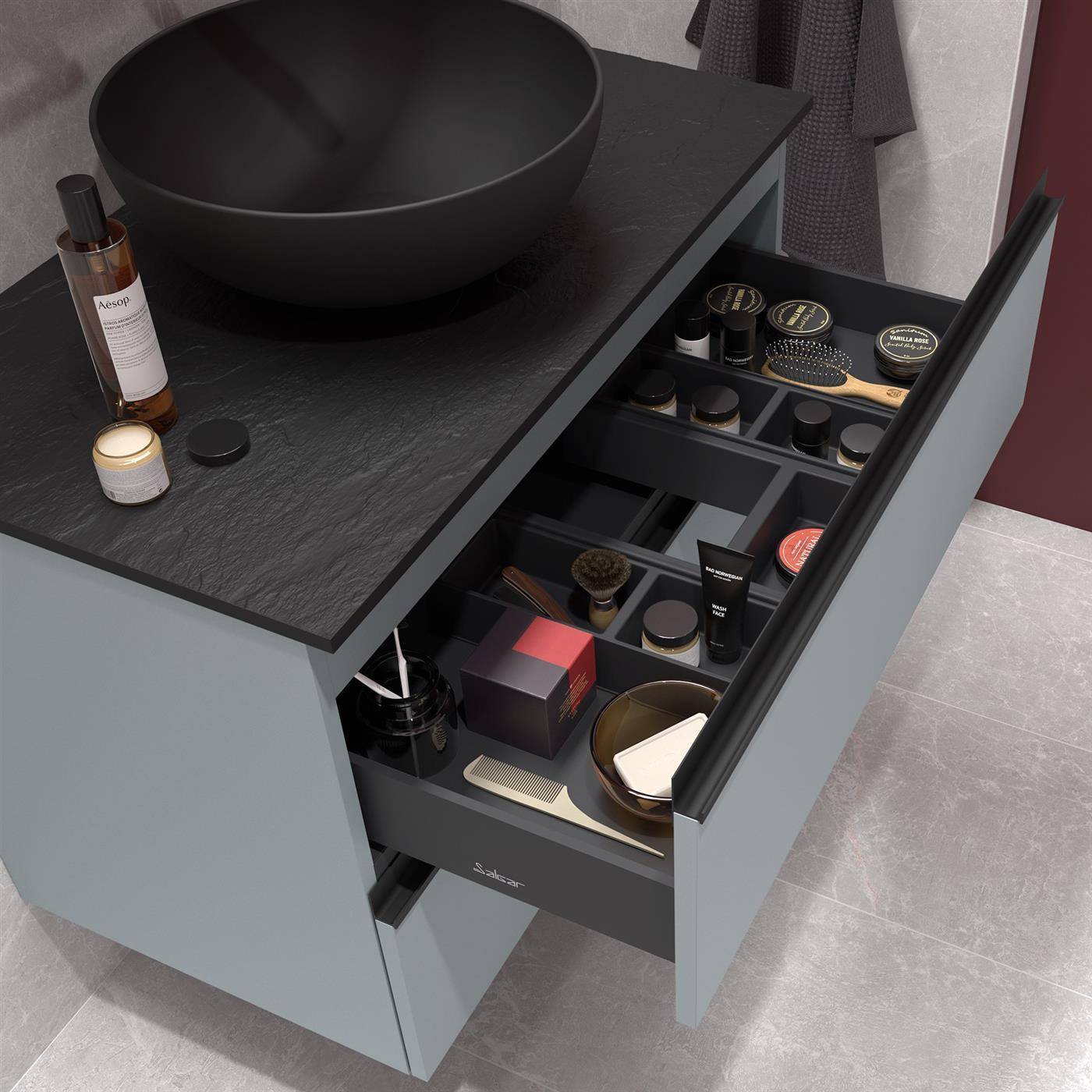 Modernes Badezimmer-Waschtischset mit schwarzem Aufsatzwaschbecken und offenem Schubladenorganizer mit Toilettenartikeln, Make-up und Körperpflegeprodukten.