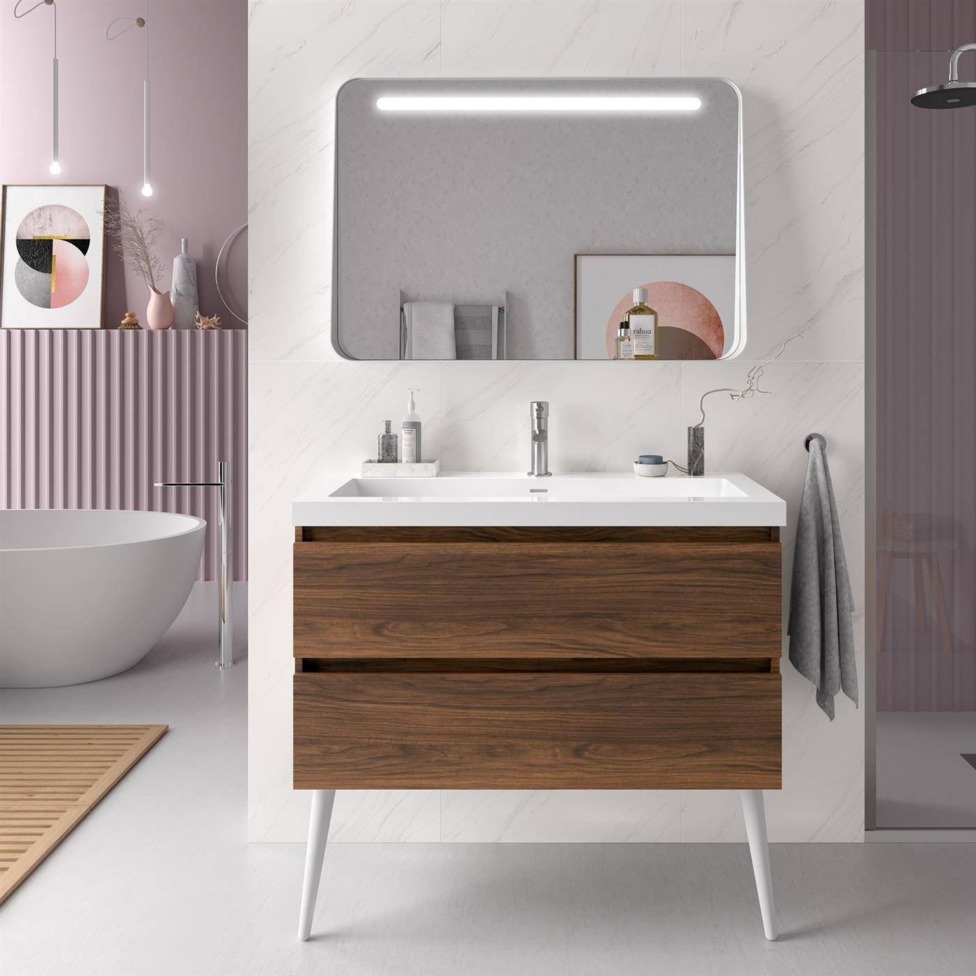 Modernes Badezimmer mit Holzwaschbeckenunterschrank, beleuchtetem Spiegel, weißem Aufsatzwaschbecken und freistehender Badewanne daneben in einem rosa und grau gestalteten Innenraum.