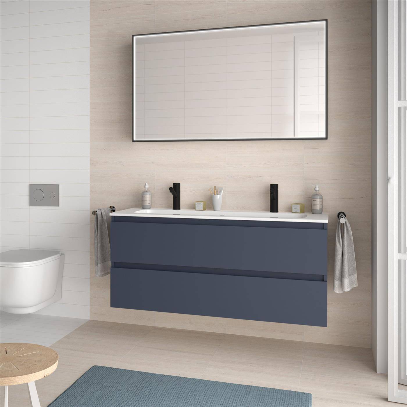Modernes Badezimmer mit wandmontiertem dunkelblauem Waschtisch, großem Spiegel, Toilette, Handtüchern und blauer Badematte; sauberes minimalistisches Interieur.