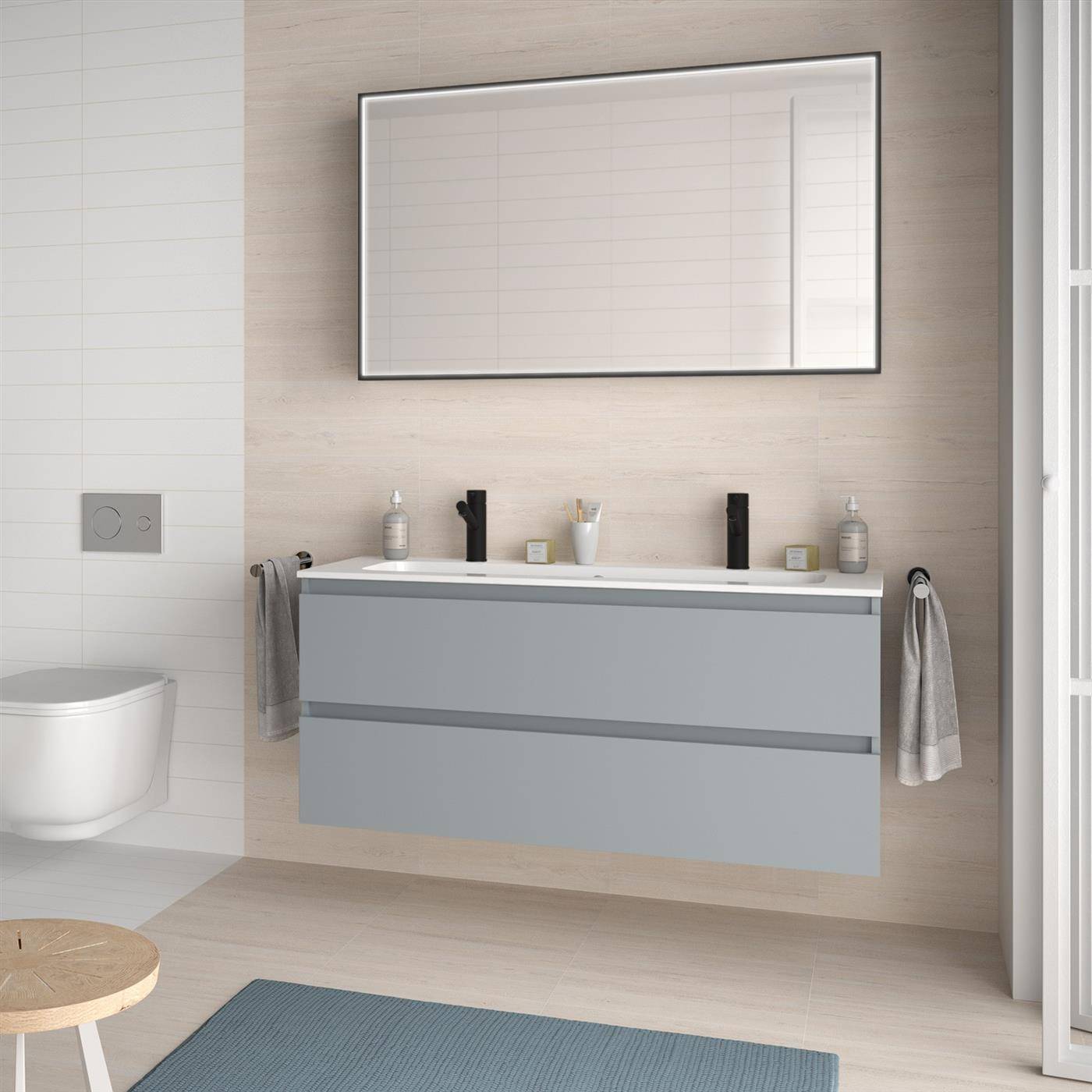 Modernes Badezimmer mit an der Wand montiertem Doppelwaschtisch, großem Spiegel, Toilette und blauem Badematte auf hellem Holzboden.