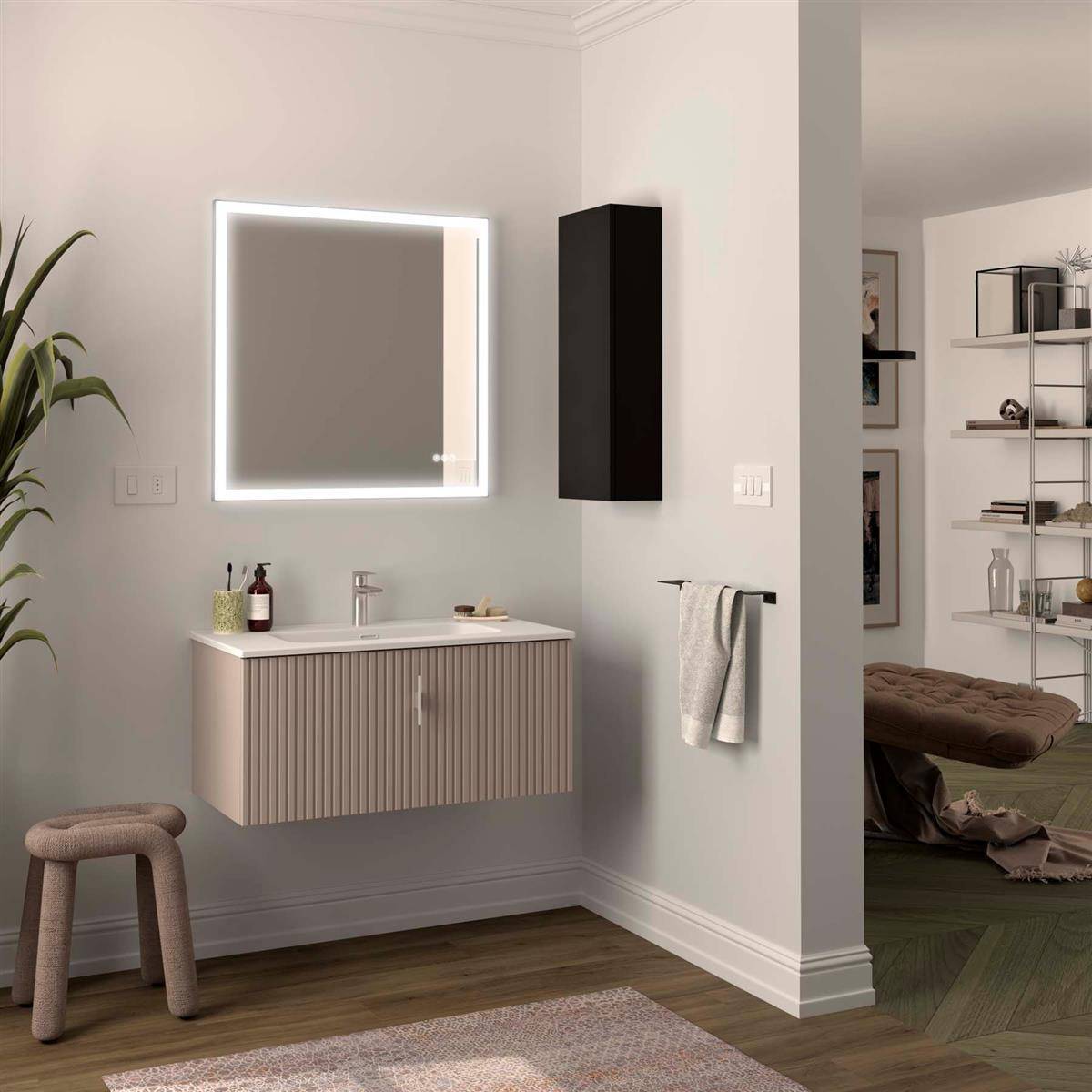 Modernes Badezimmer mit beleuchtetem Spiegel, Waschbecken, Handtuchhalter und Hocker; die Türöffnung zeigt ein Schlafzimmer mit Regalen.