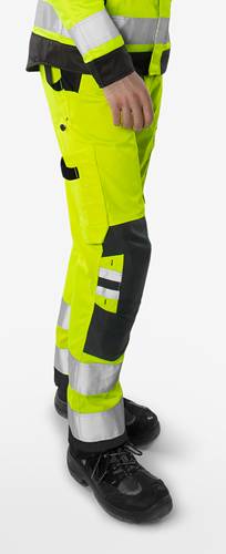 Person trägt gelbe Warnschutz-Arbeitshose mit Reflektorstreifen.