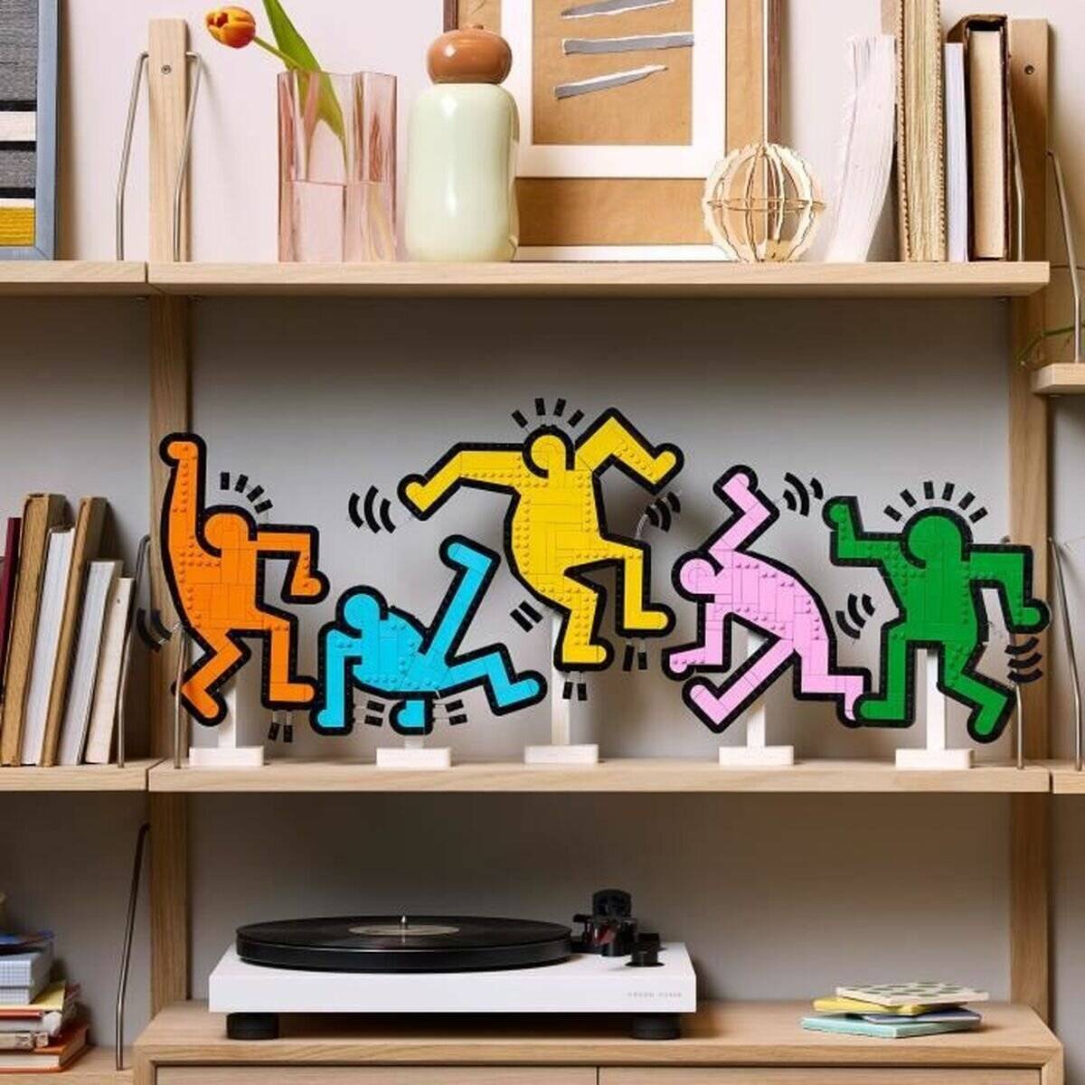 Bunte Keith Haring-Stil Tänzer-Figuren auf einem Regal, wie kleine Kunstobjekte in einer Wohnzimmereinrichtung ausgestellt.