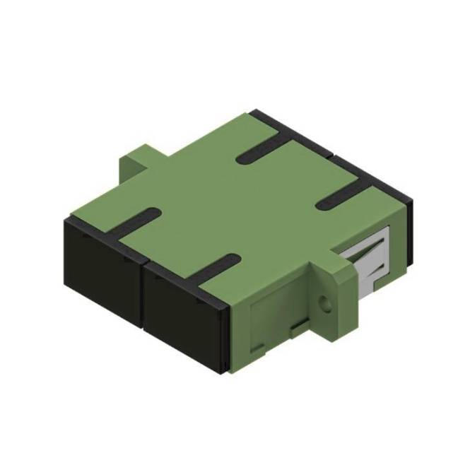 Eine kleine, grün-schwarze elektronische Komponente, möglicherweise ein Stecker oder Modul, mit geometrischen Formen und einer metallischen Kante.